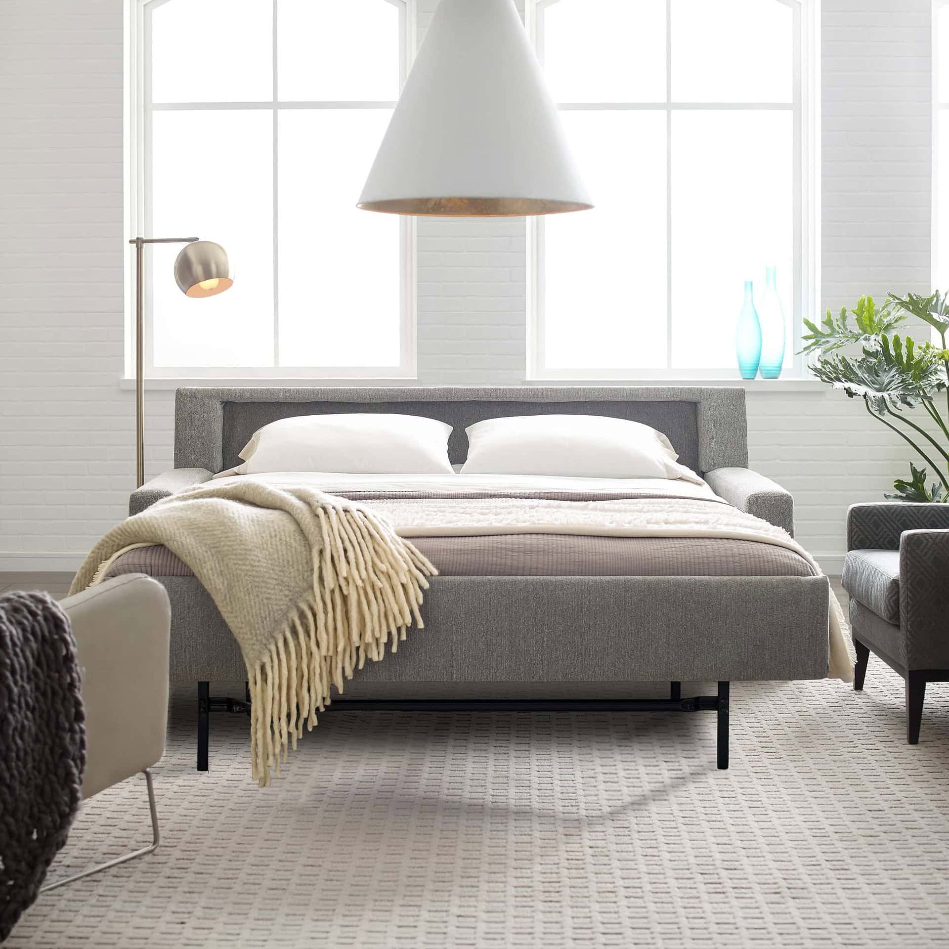 Bright bedroom with contemporary furniture, large windows, and decorative accents, showcasing Sklar Furnishings' stylish designs.