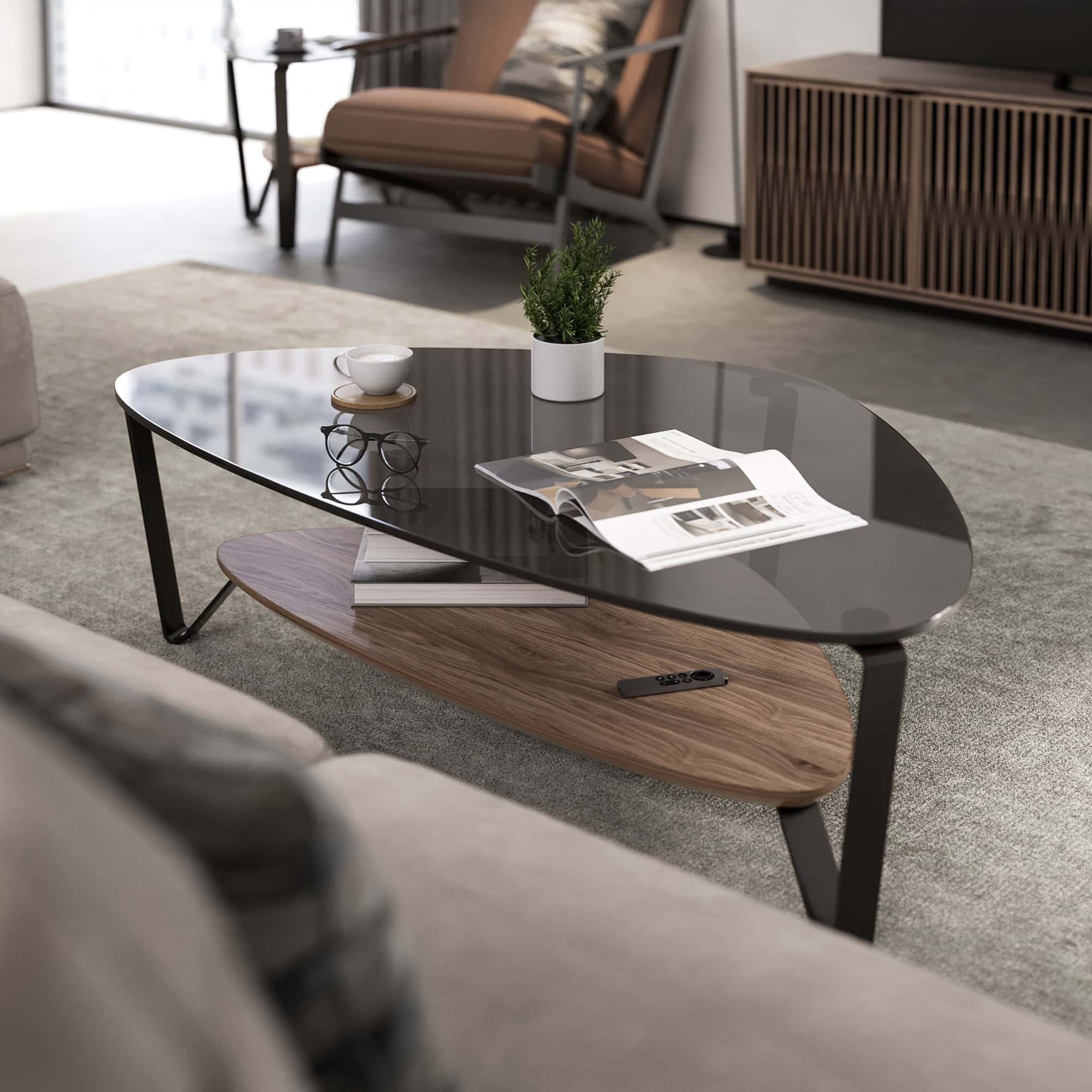 Modern living room coffee table with glass top, wooden shelf, and remote control, styled by Sklar Furnishings.