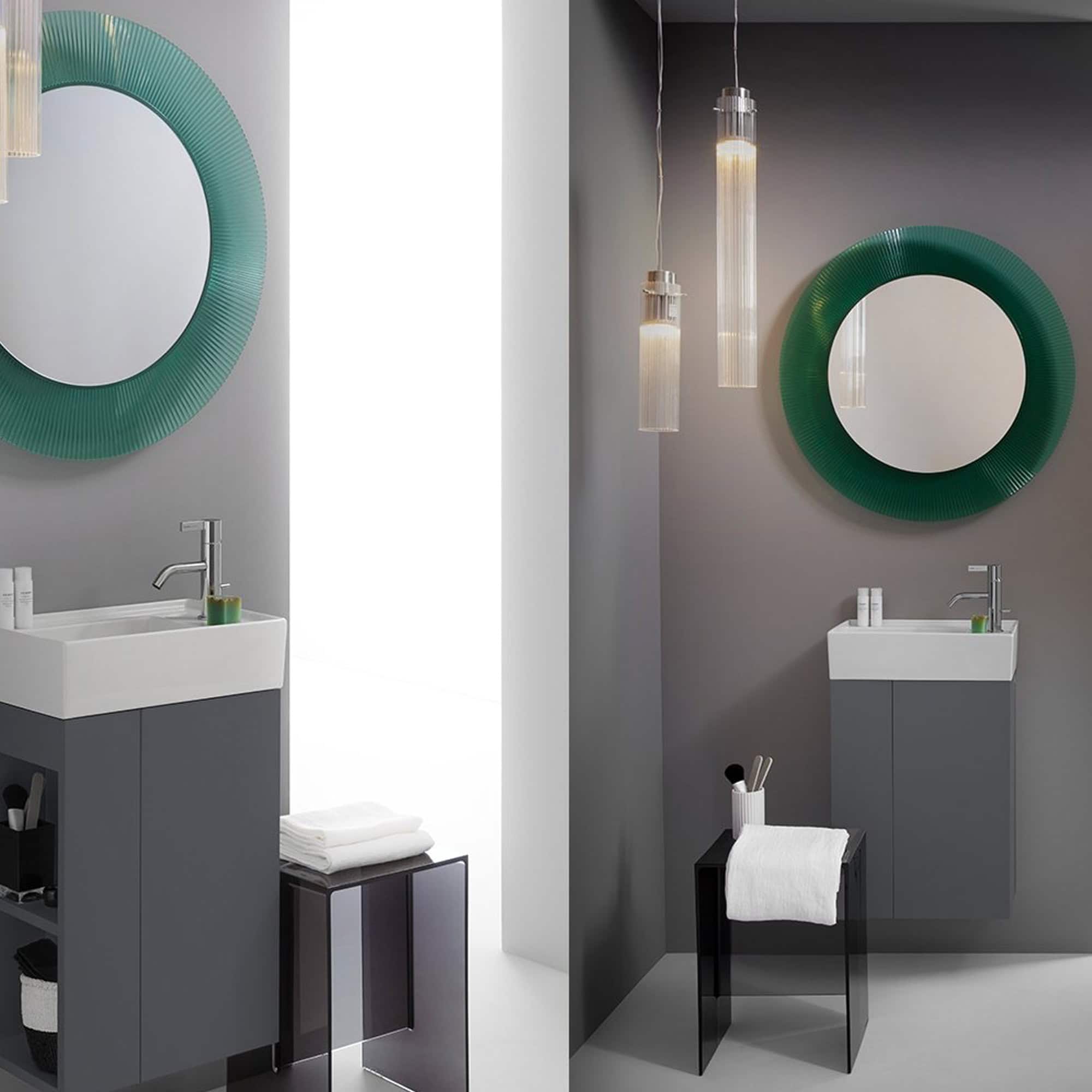 Kartell All Saints round mirror with pleated green frame mounted on a gray wall in a sleek bathroom.