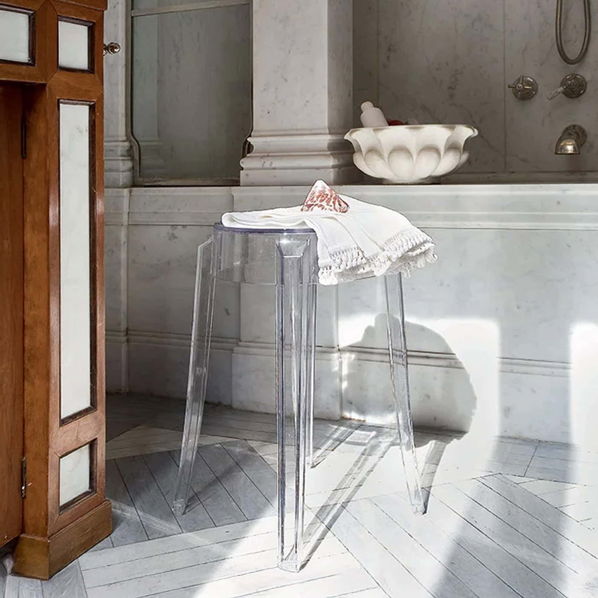 Clear Charles Ghost stool placed in a minimalist bathroom setting.