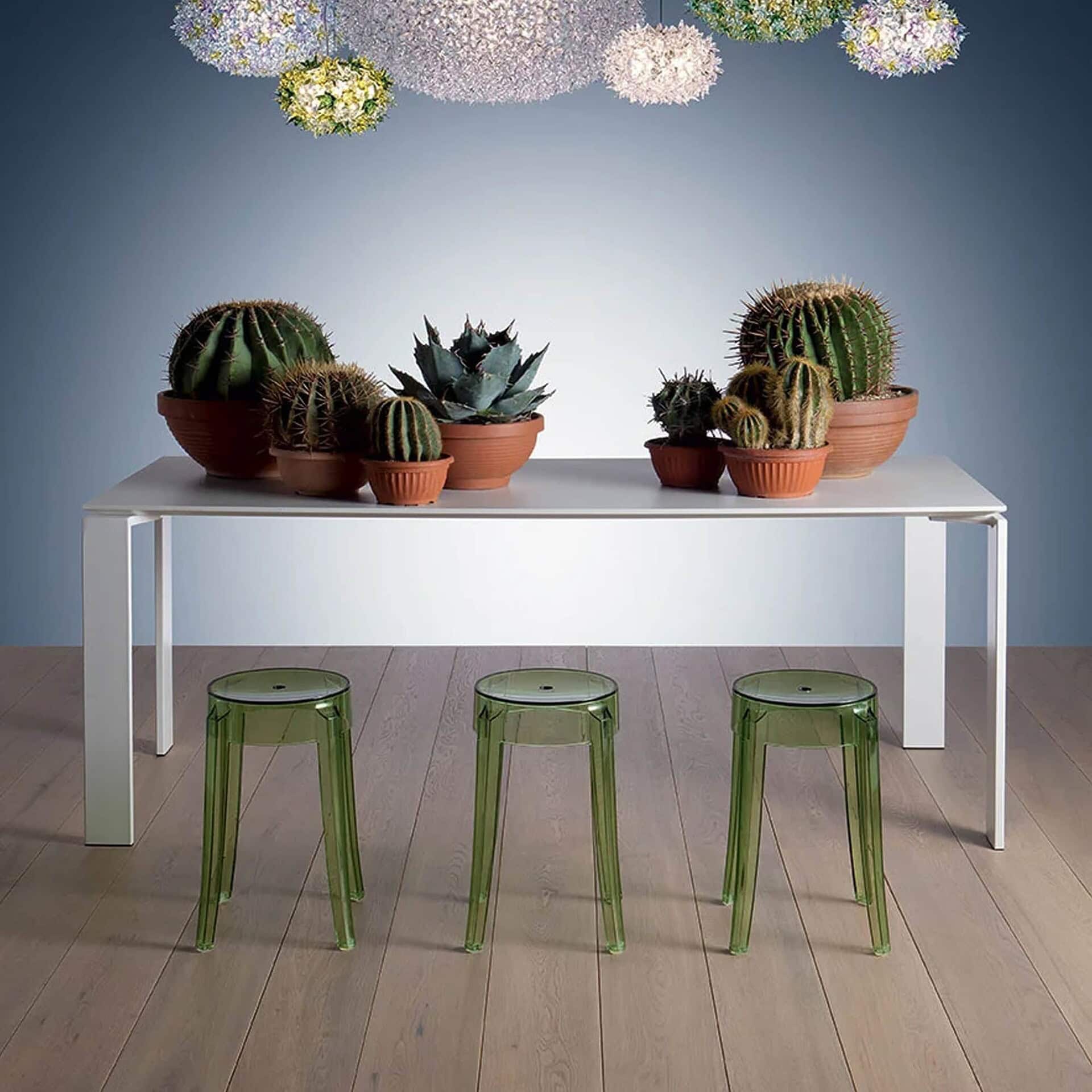 Green Charles Ghost stools paired with a white dining table in a bright room.