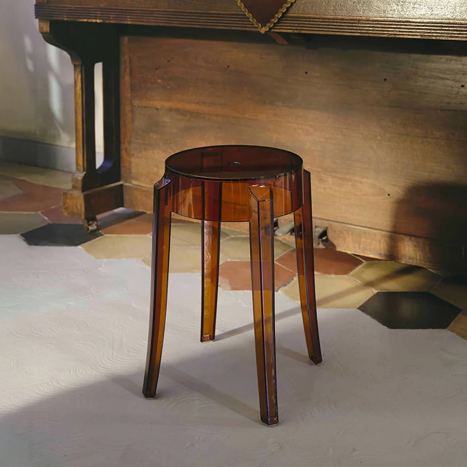 Brown Charles Ghost stool placed in a rustic wooden interior.