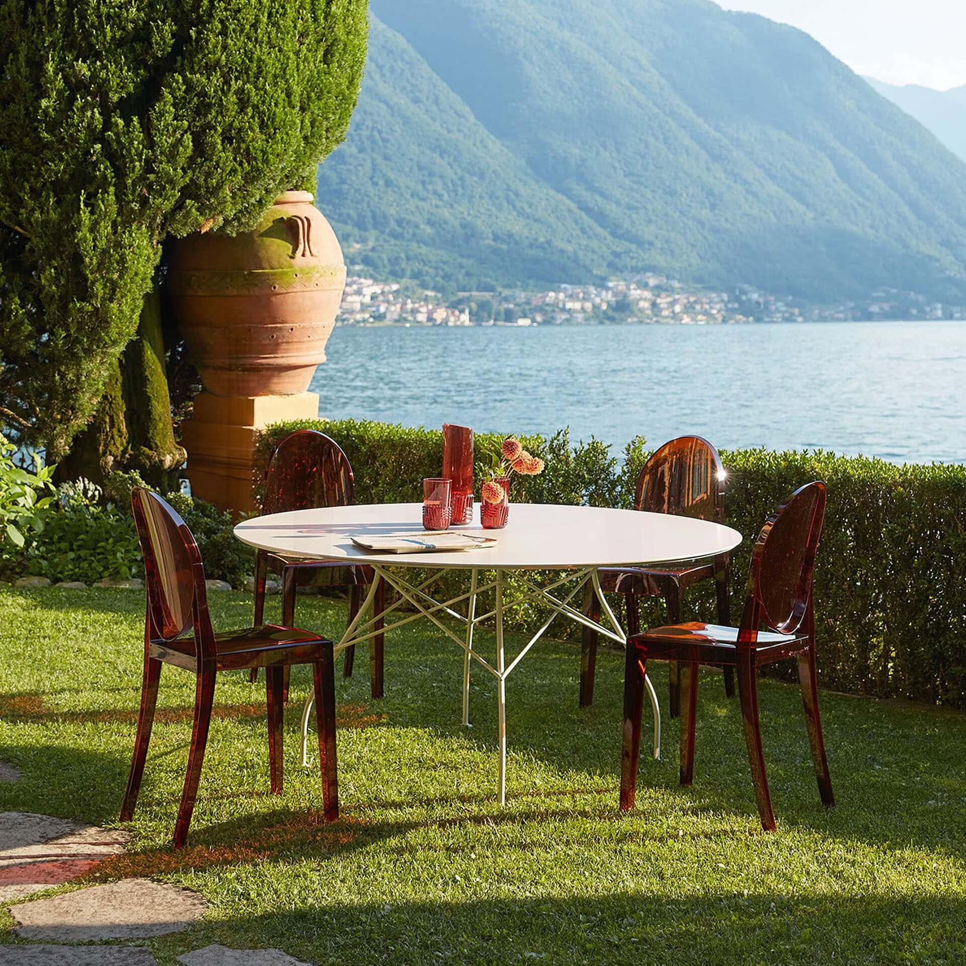 Outdoor dining table with four chairs by the lake, perfect for scenic gatherings.