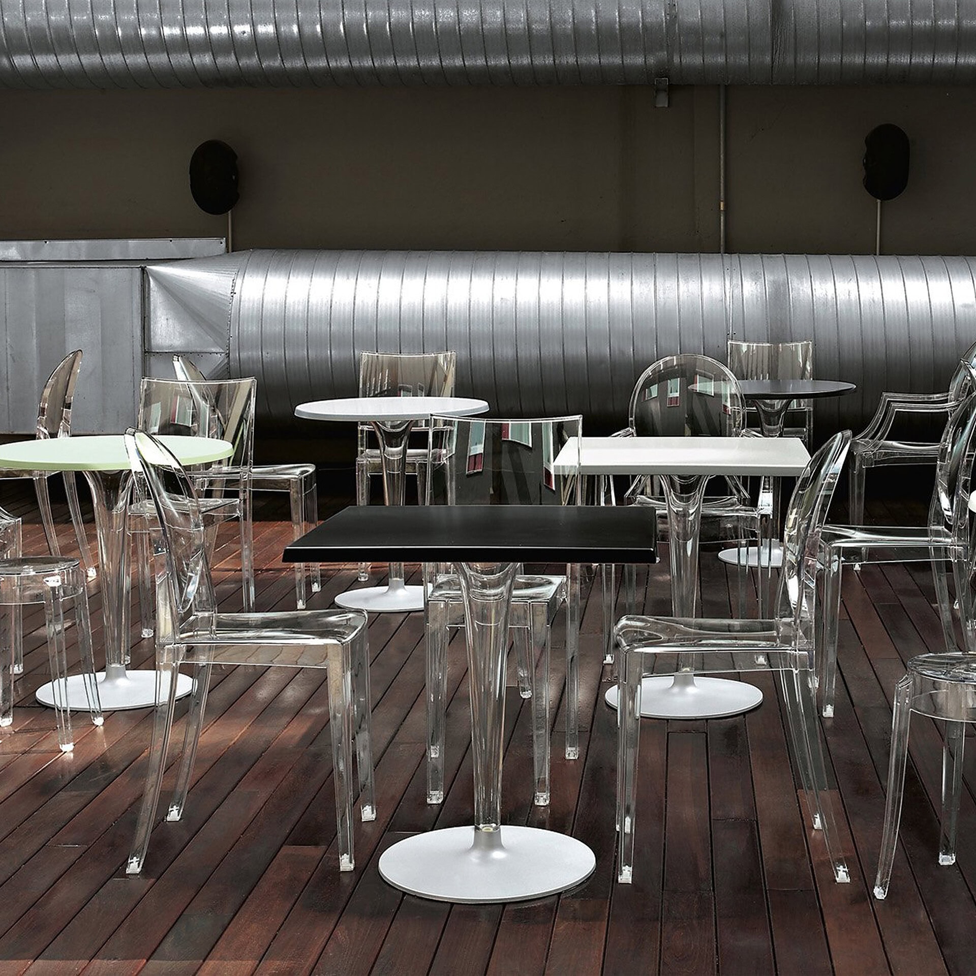 Elegant glass dining tables and chairs in a contemporary restaurant interior.