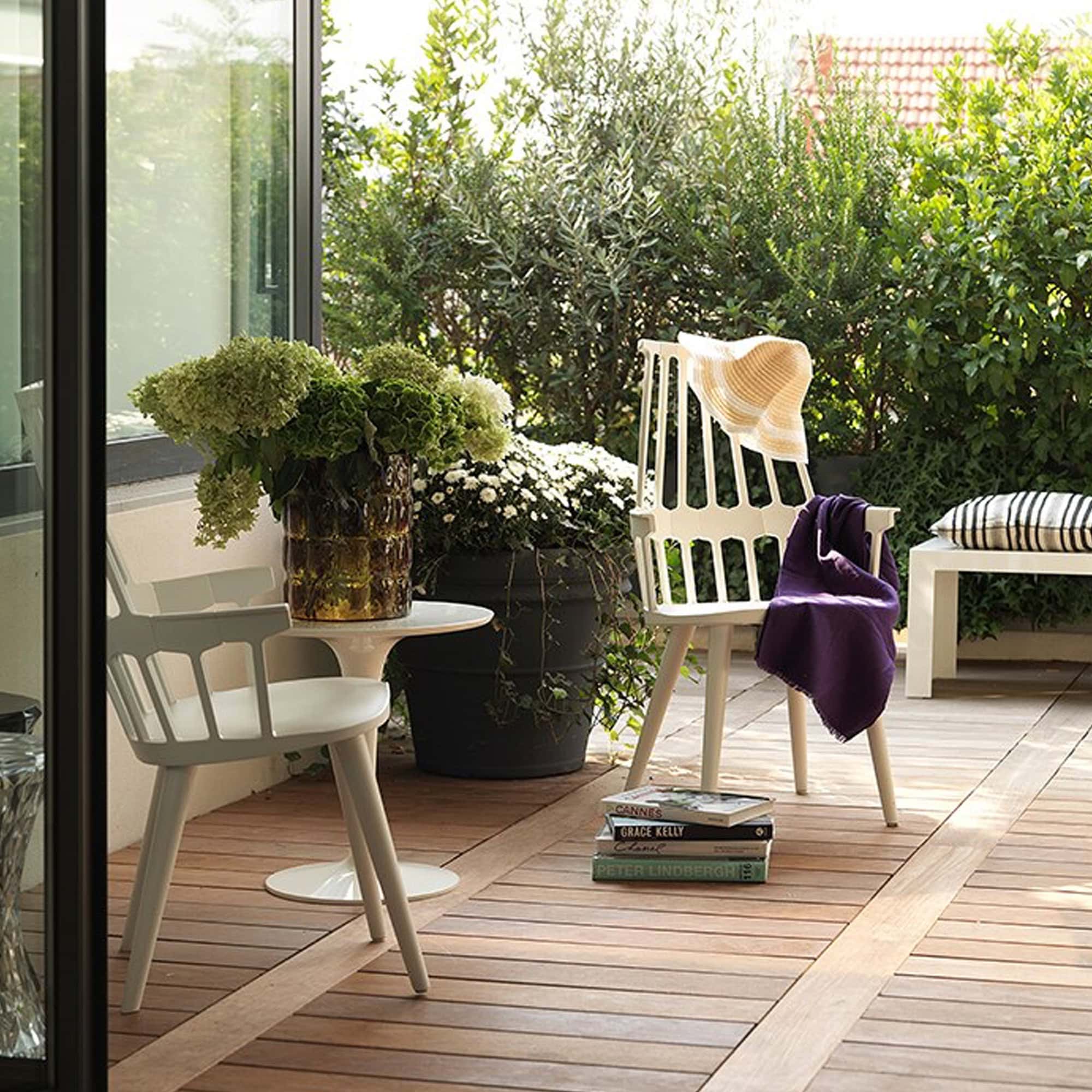 Tip Top Table in outdoor patio setting with plants and lounge chairs.
