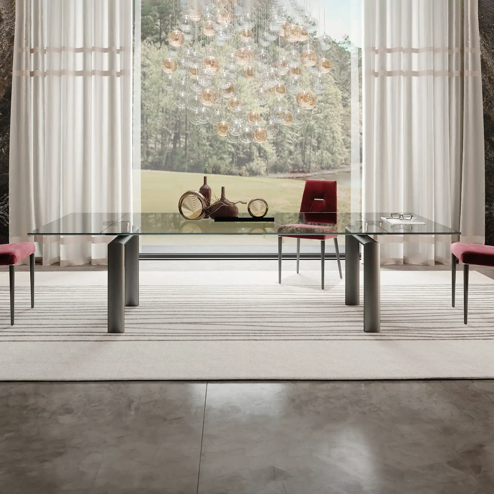 Modern glass extending dining table with pink chairs in bright room.