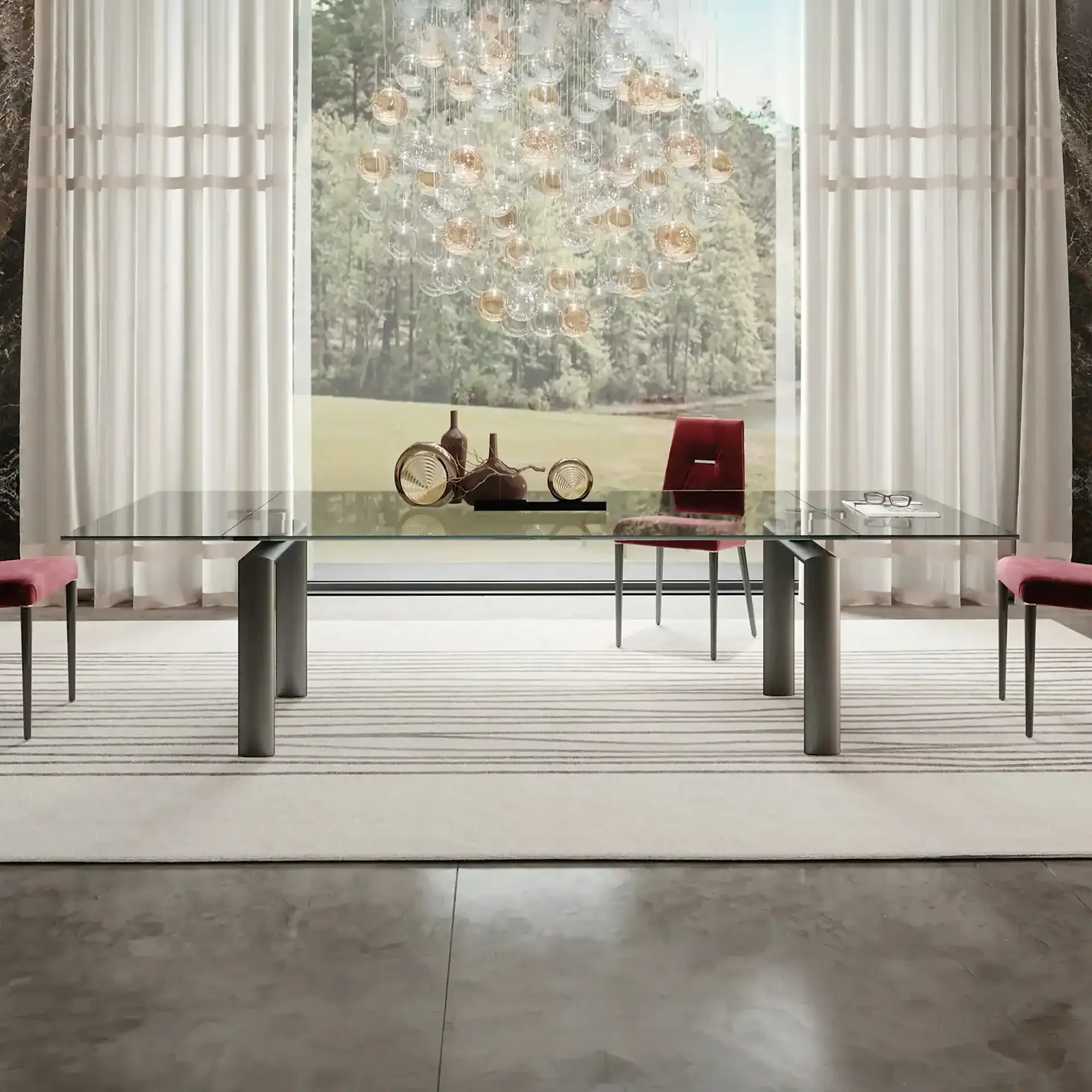 Policleto extendable dining table with glass top and metal legs in a modern dining room.