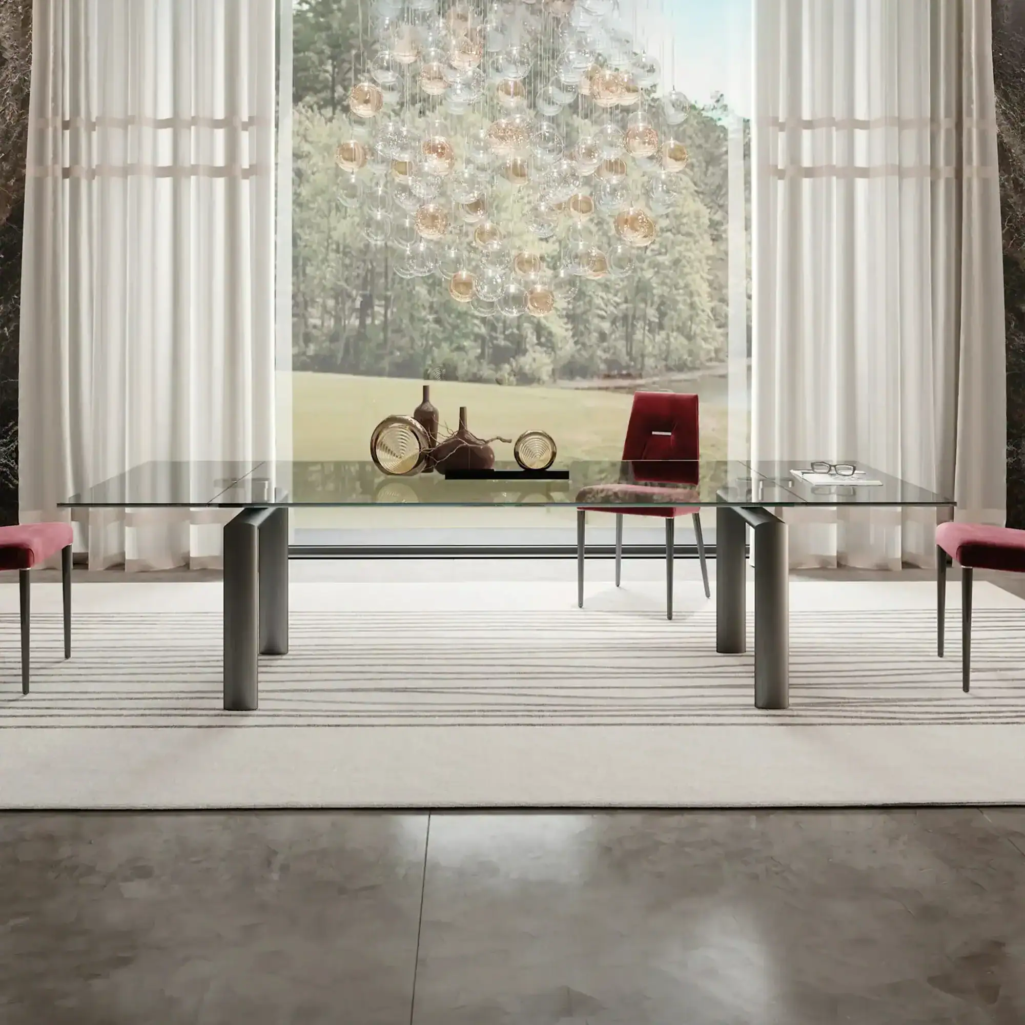Policleto extendable dining table with glass top and metal legs in a modern dining room.