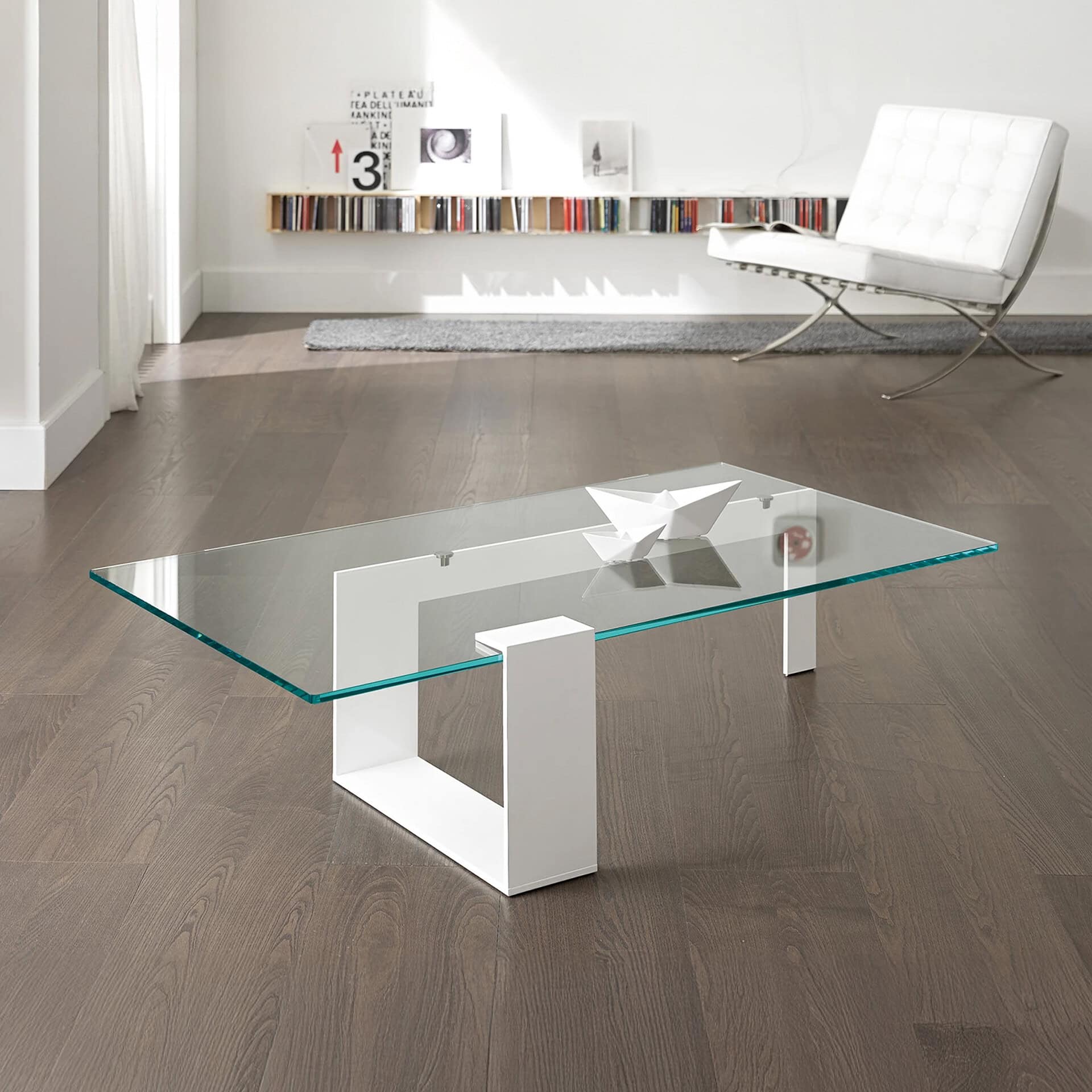 Plinsky Glass Low Coffee Table with clear glass top and white lacquered metal base in a minimalist interior.
