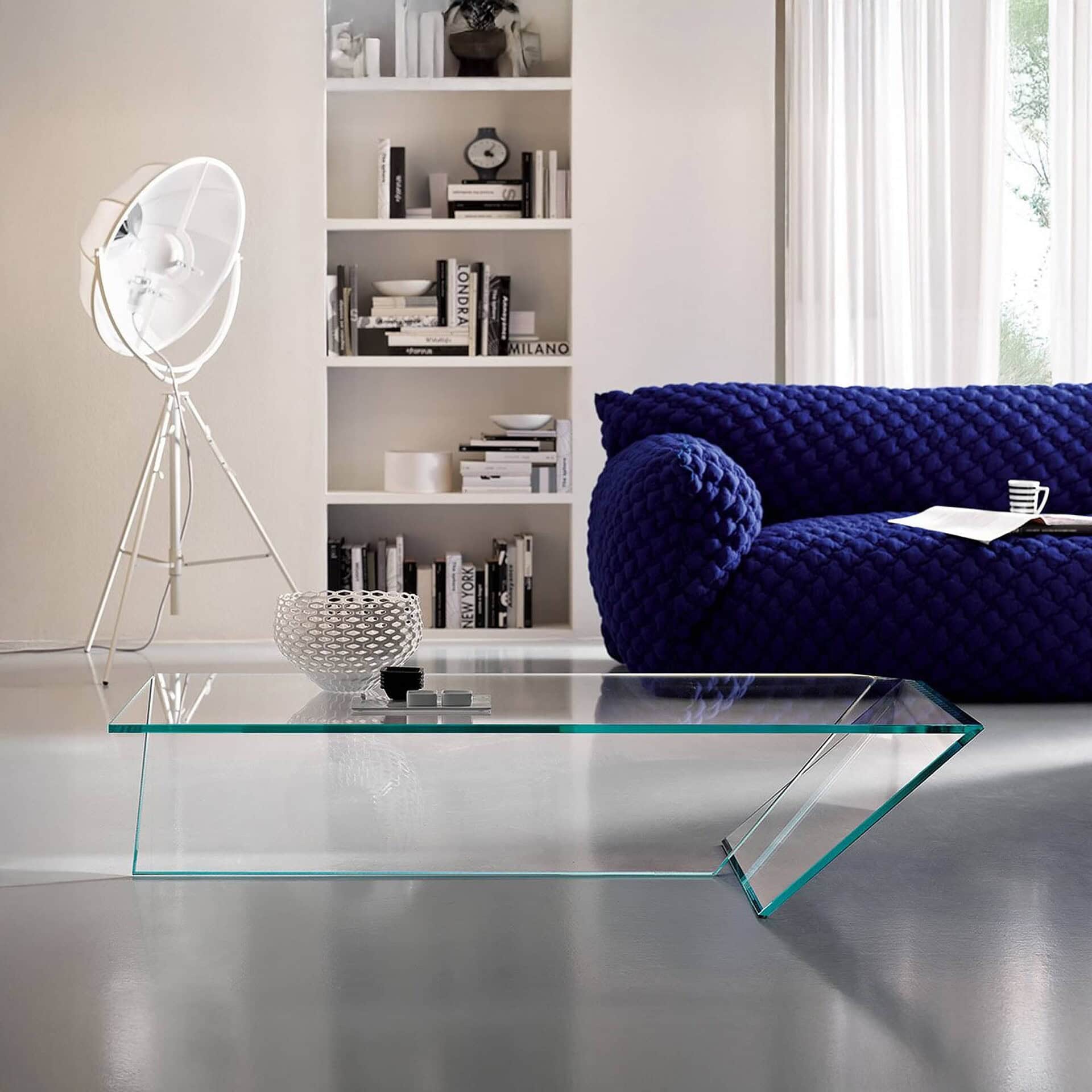 Ti Low Table in a contemporary living room with glass structure and angled design, styled with a bold blue sofa.