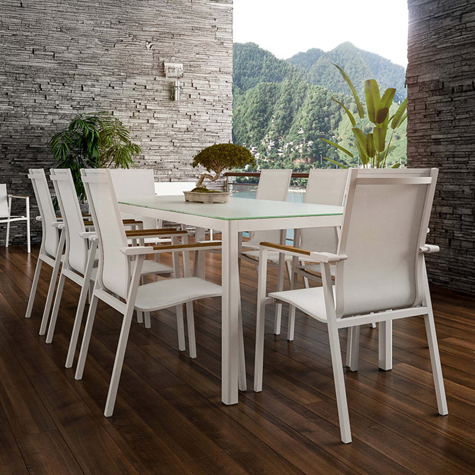 Outdoor dining setup featuring multiple Ella Dining Chairs in white with teak armrests around a rectangular dining table