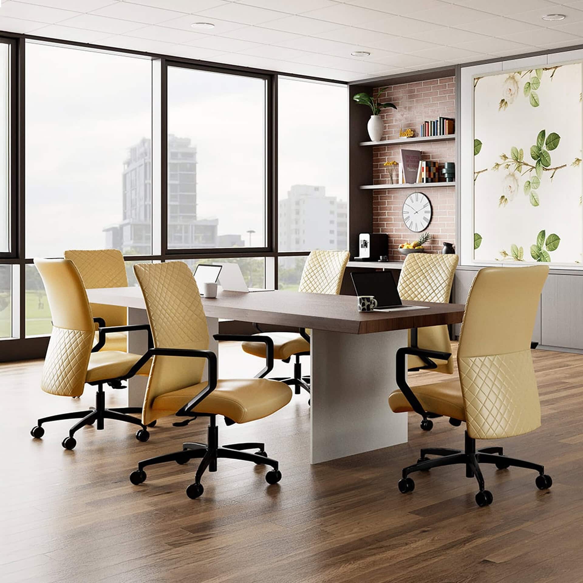 A modern conference room with a large dark wood table, six mustard yellow quilted chairs, and floor-to-ceiling windows overlooking a city. The room has a brick accent wall with shelves and a floral decorative panel.