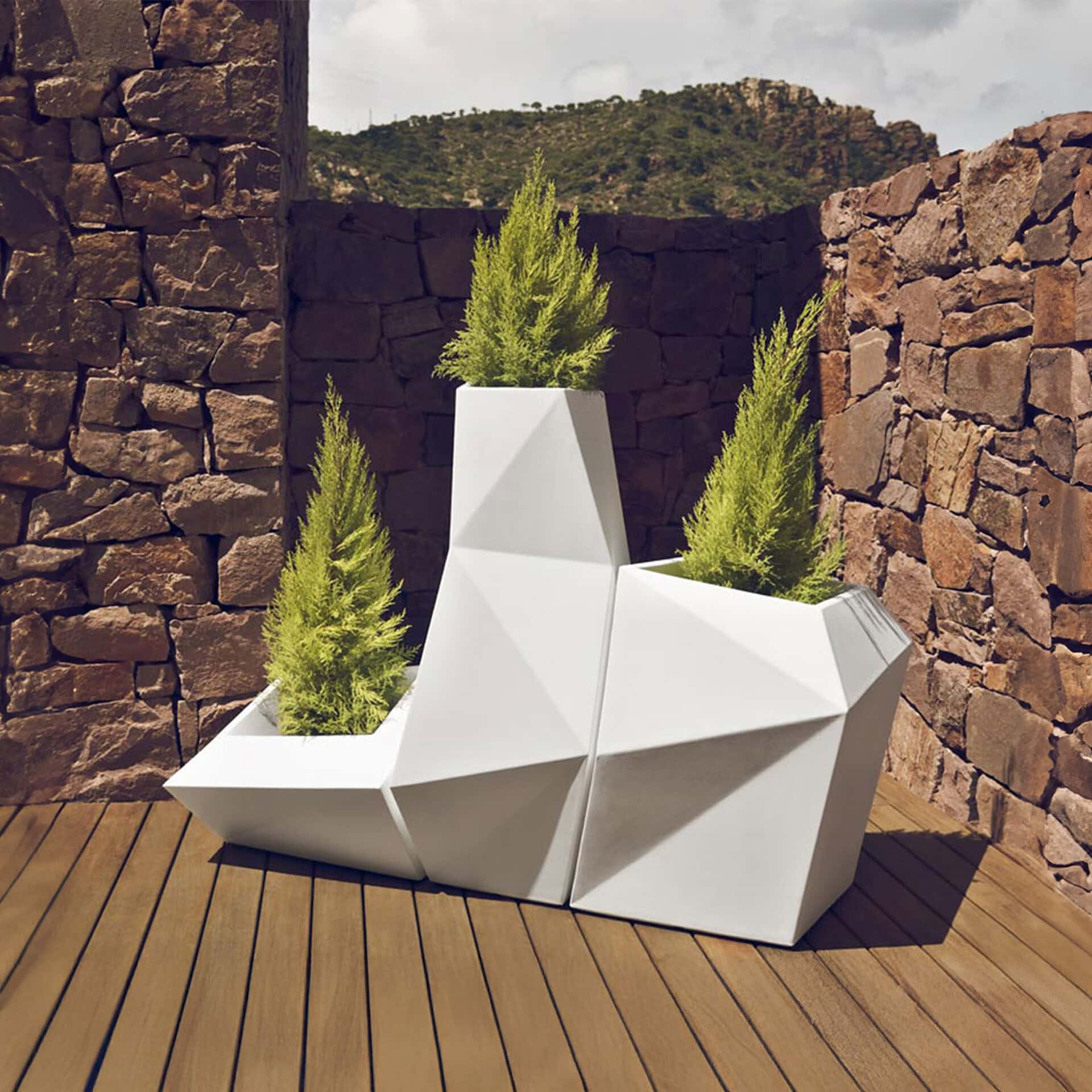 Geometric white outdoor planter with lush green plants, perfect for patios or gardens. Stylish, cont.