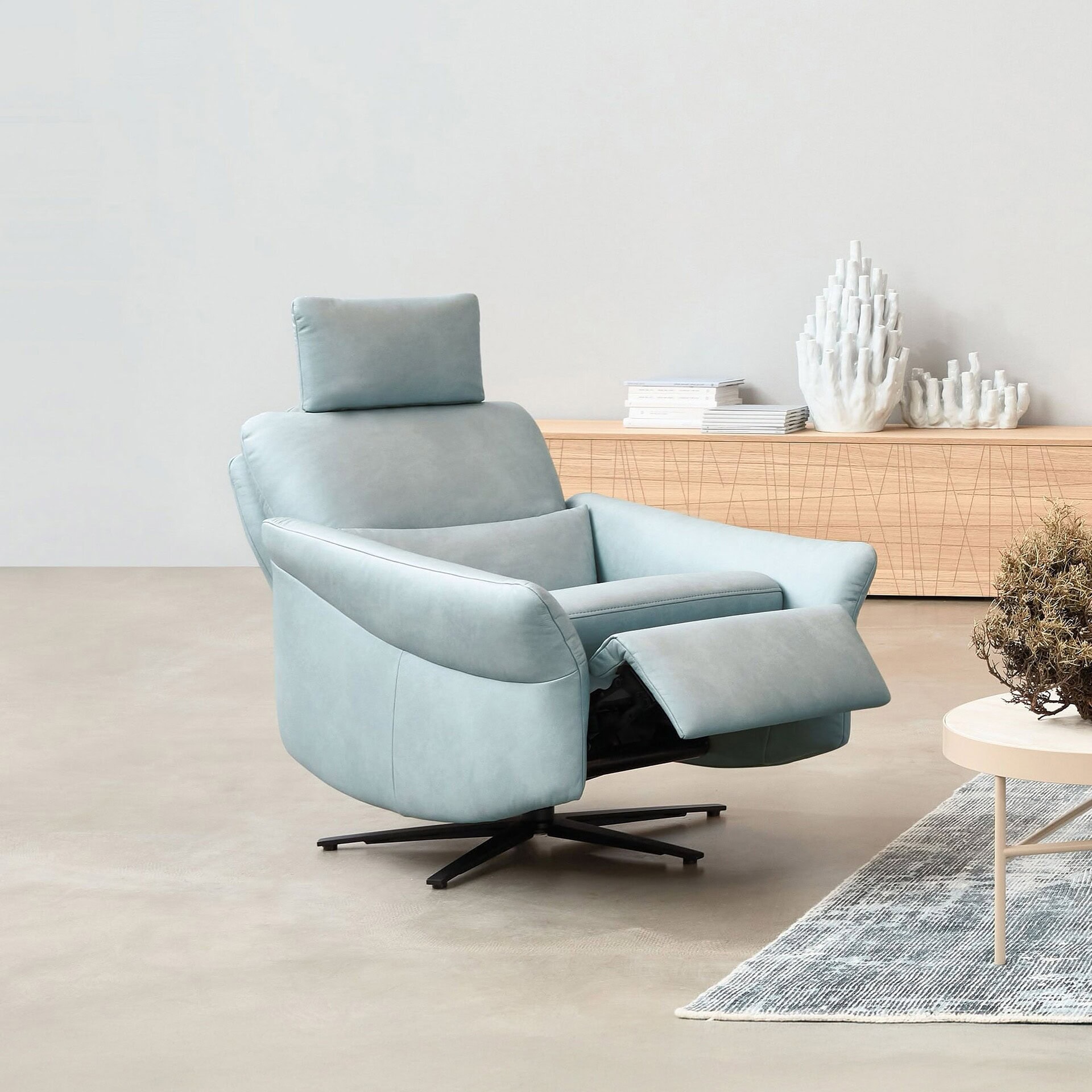 Modern Himolla recliner chair in light blue fabric with adjustable footrest.