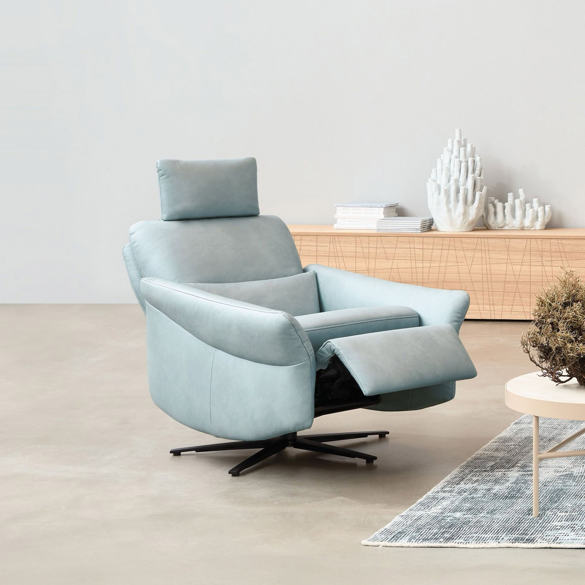 Modern Himolla recliner chair in light blue fabric with adjustable footrest.