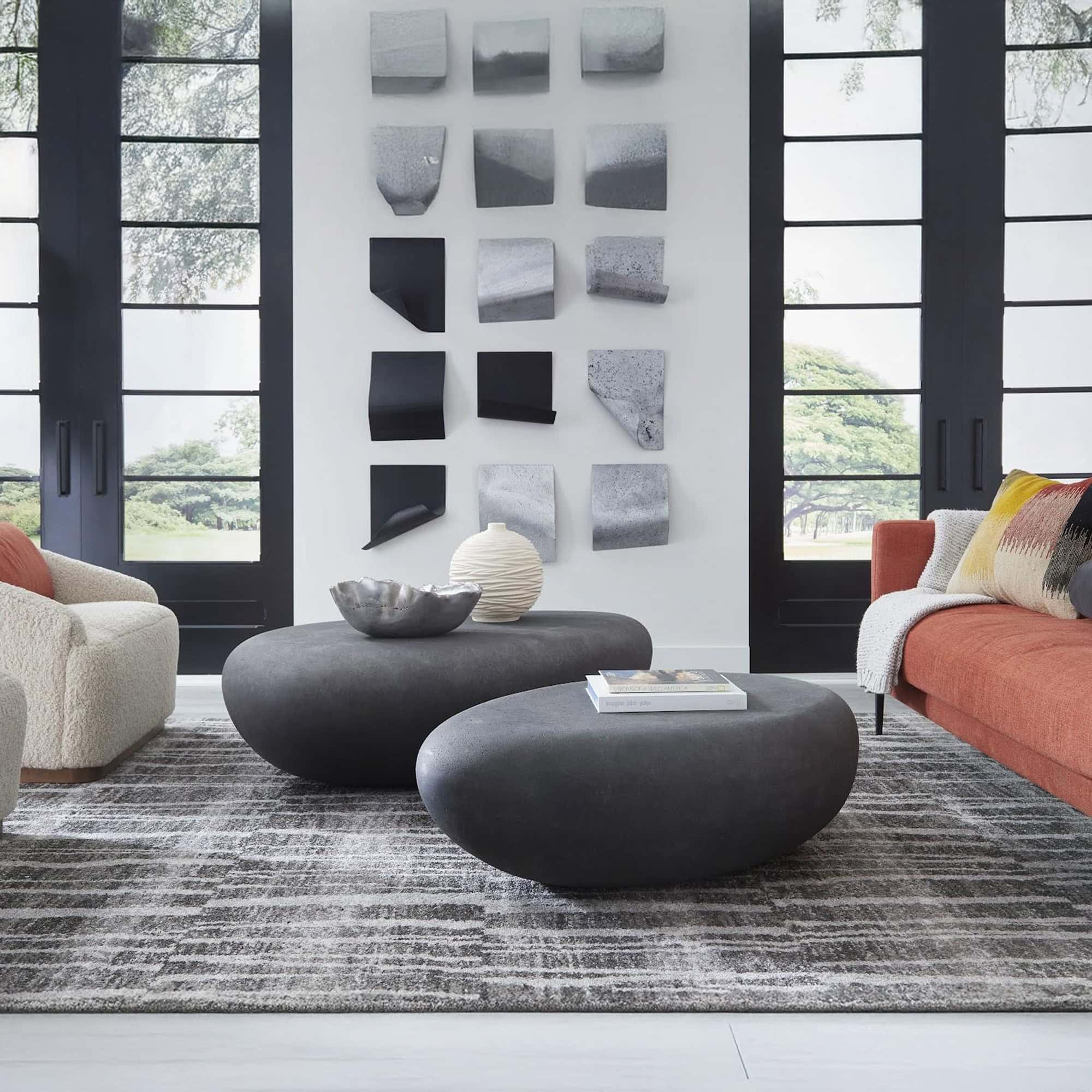 Charcoal Stone River Stone Coffee Tables in modern living room with gray sofa.