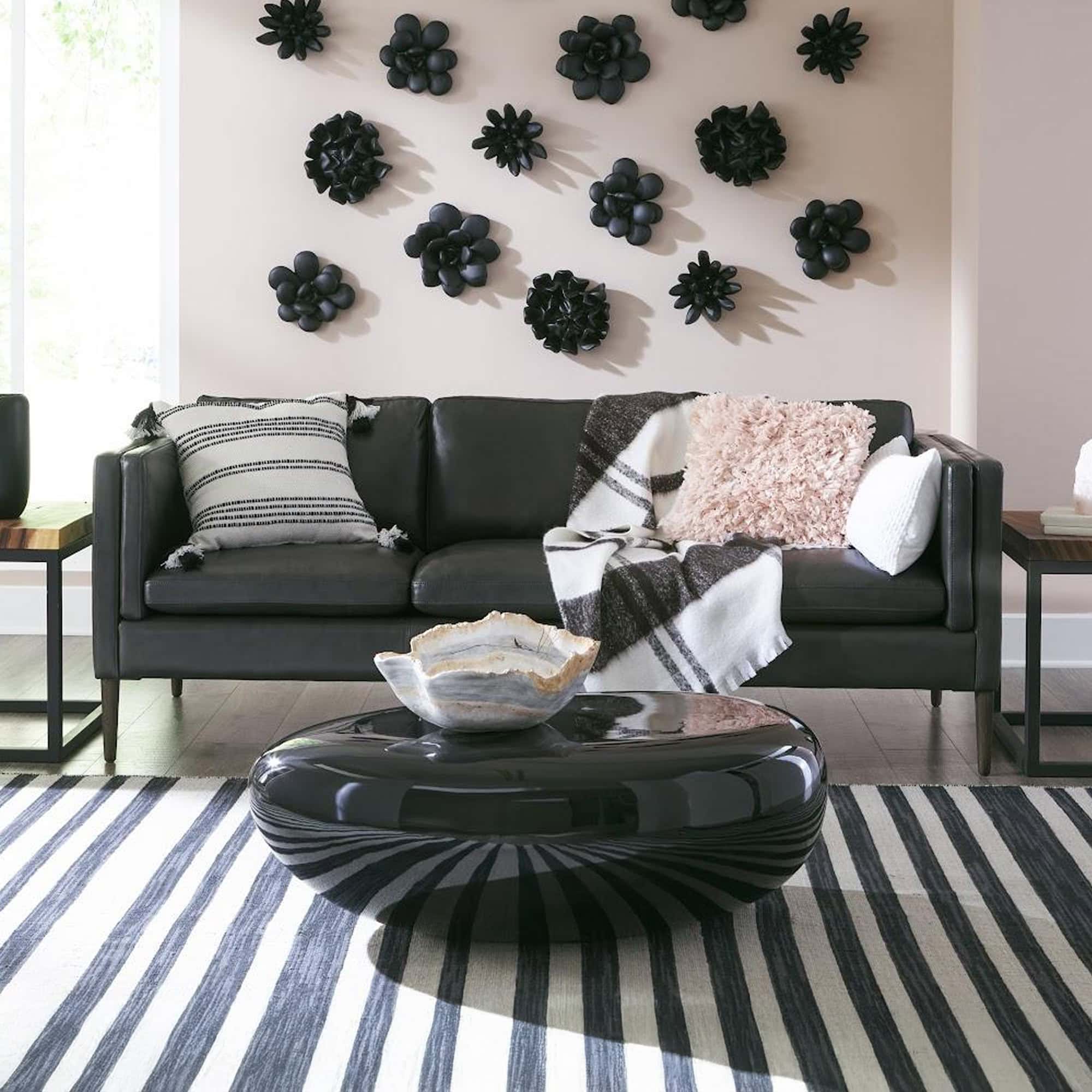 Liquid Silver River Stone Coffee Table styled with greenery in striped rug setting.