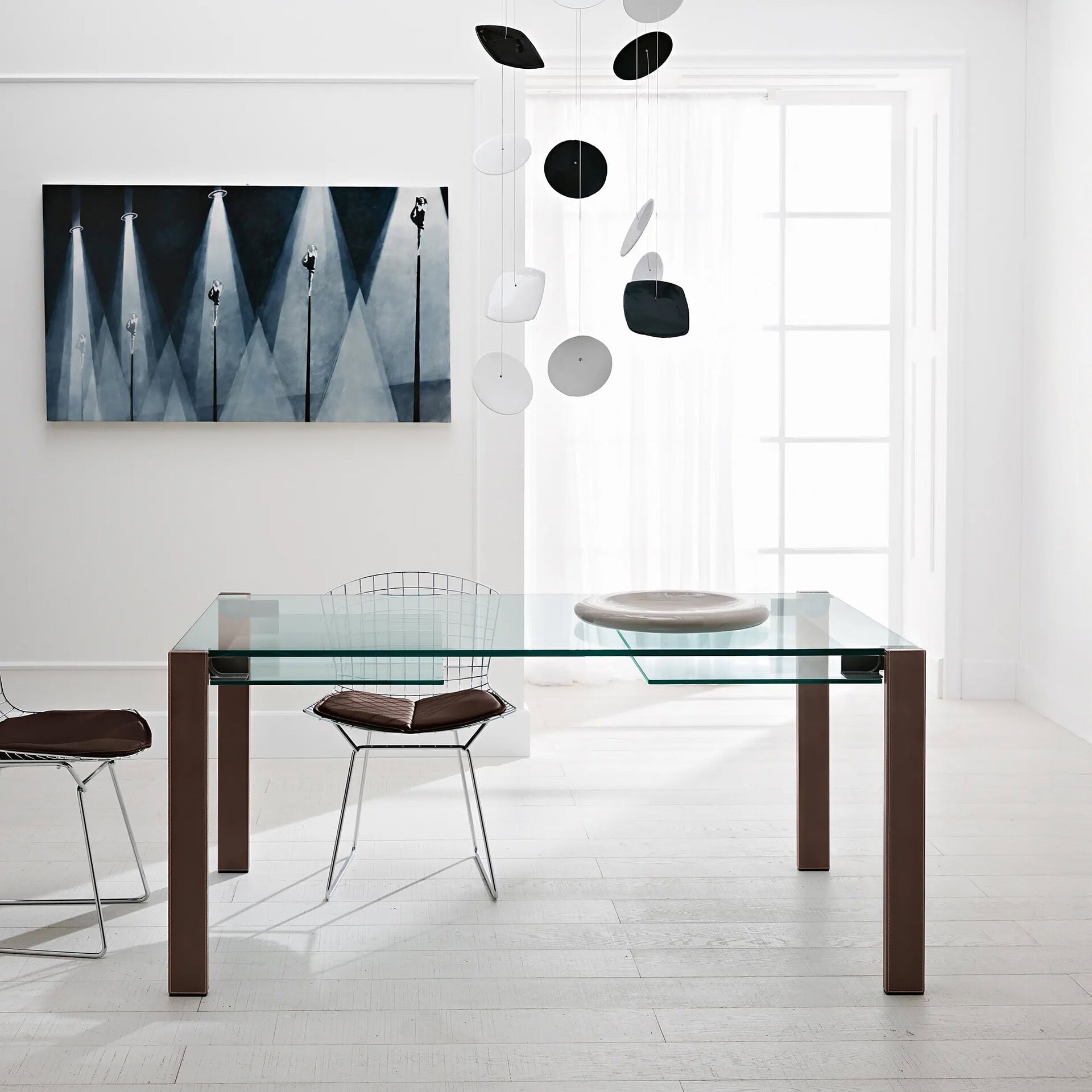 Livingstone Extendable Dining Table styled with decor, featuring extra clear glass top and walnut legs