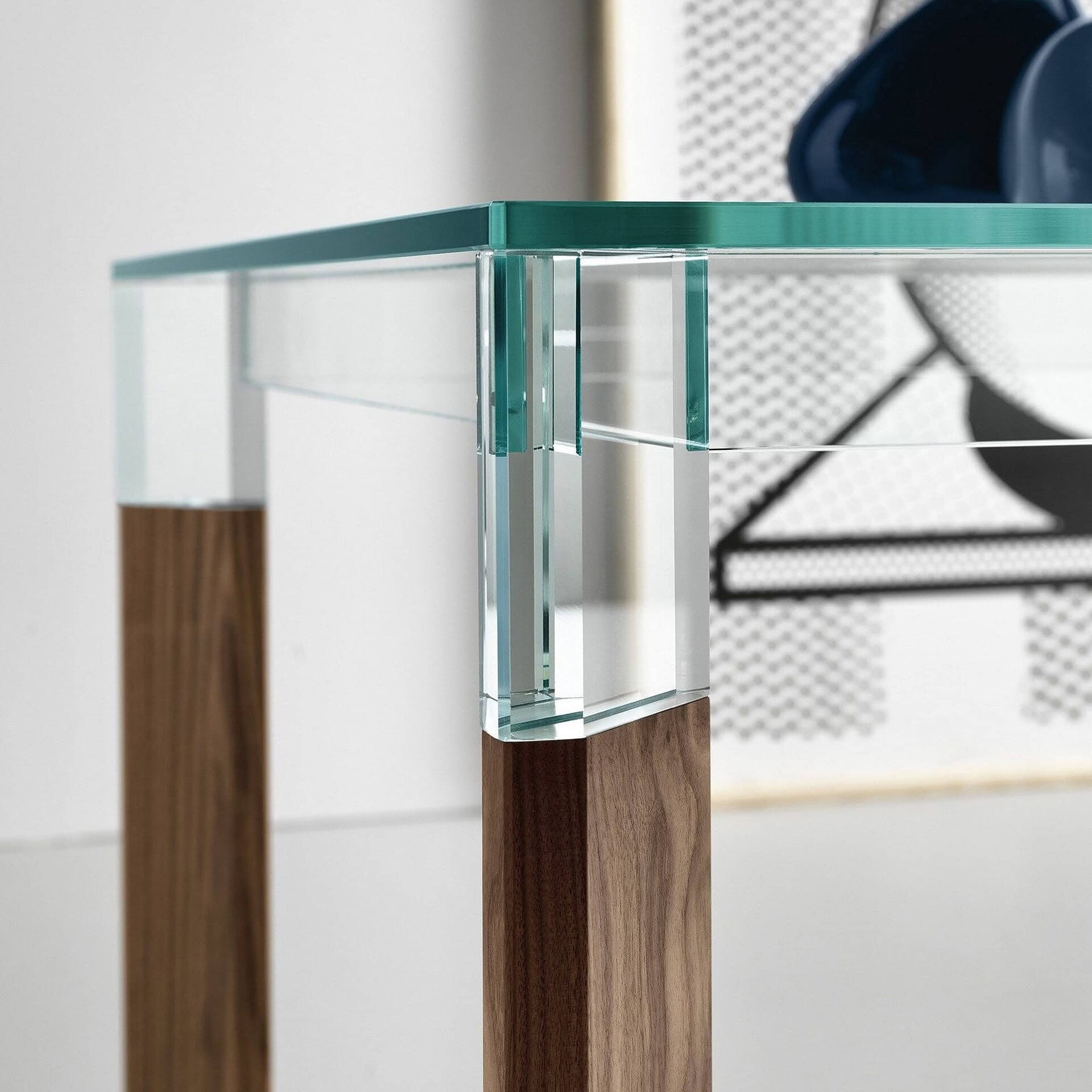 Close-up of Perseo Extra-Clear Glass Dining Table showing Canaletto walnut leg connection