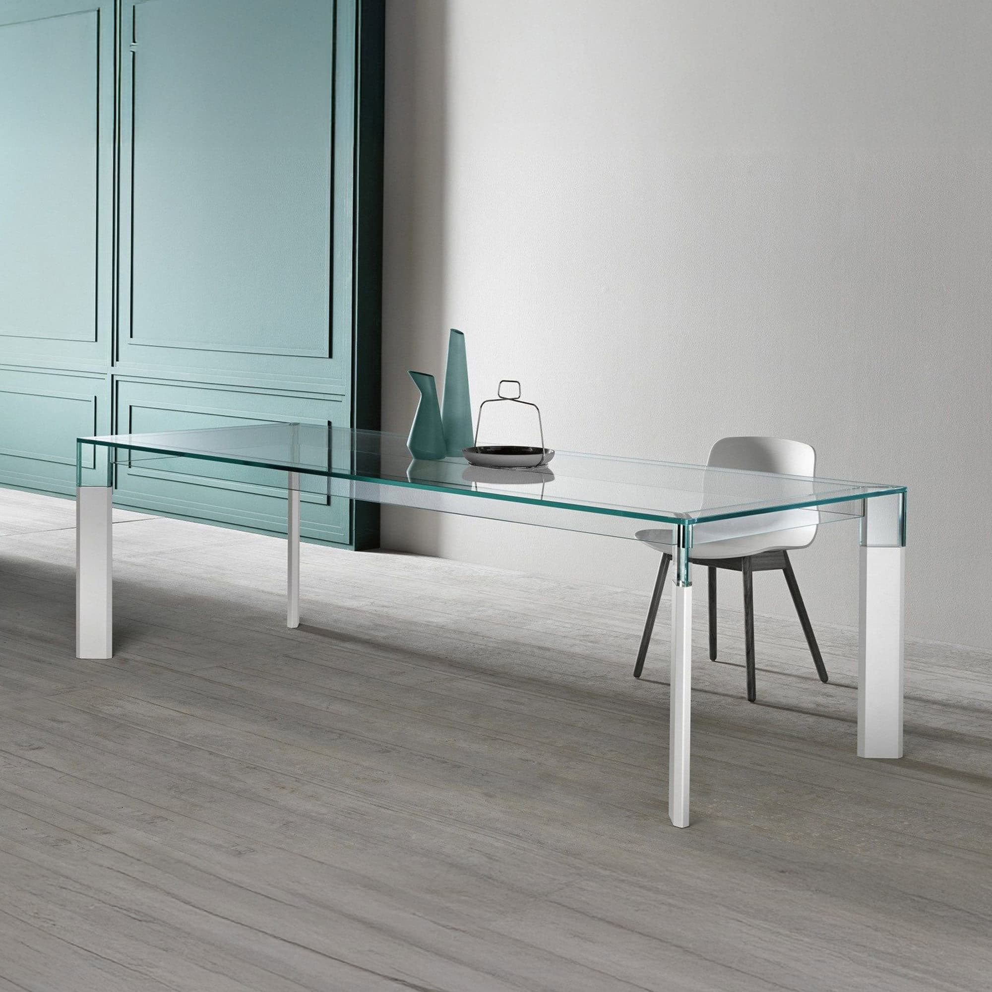 Perseo Extra-Clear Glass Dining Table with white legs placed in a bright interior setting