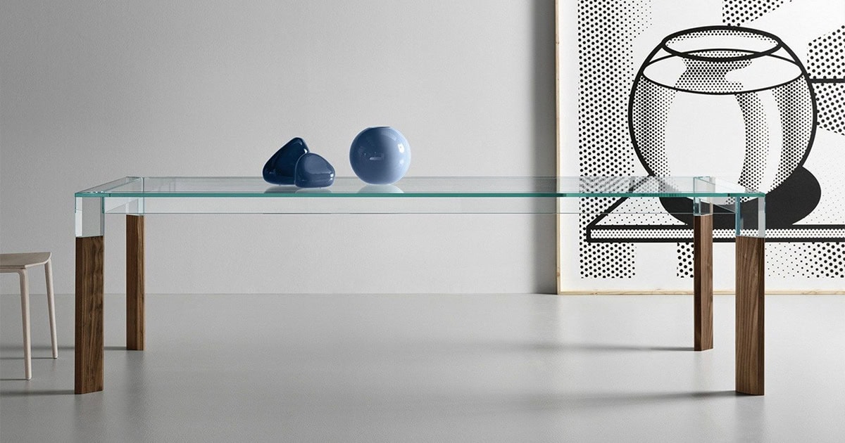 Perseo Extra-Clear Glass Dining Table with natural wood legs styled in a minimalist dining room