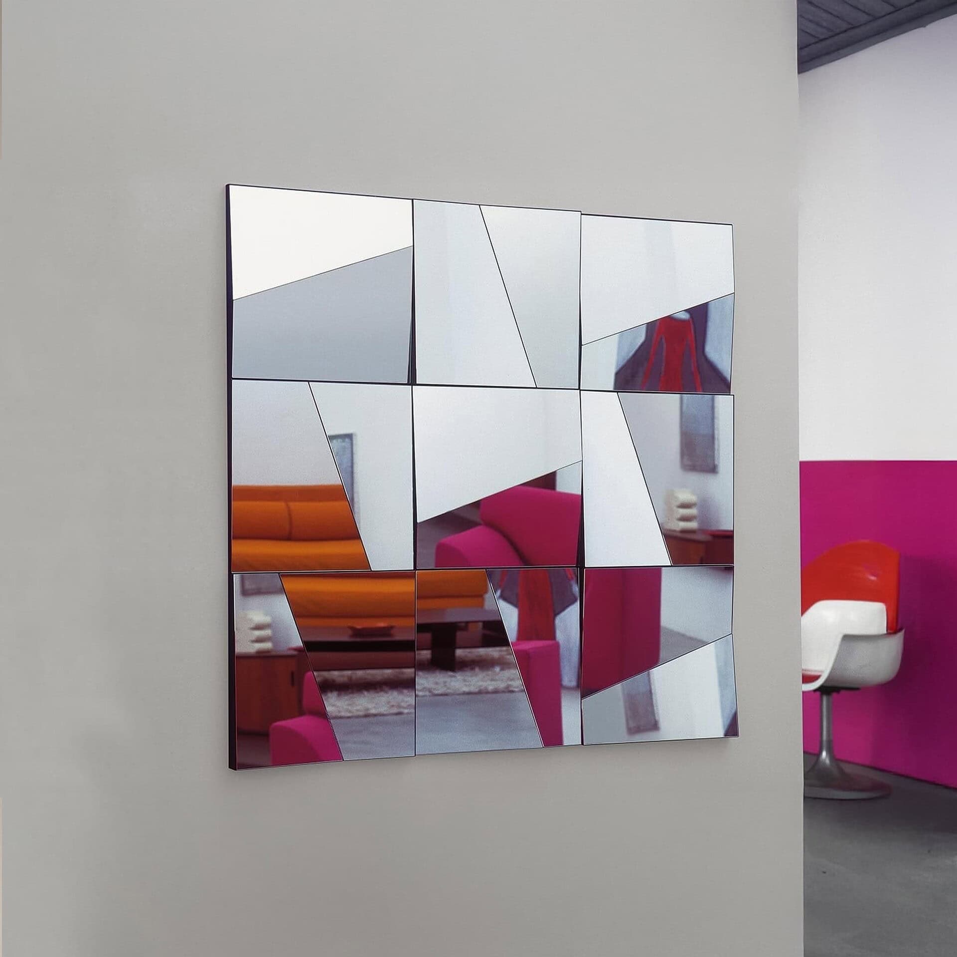 Stati d’Animo wall mirror reflecting colorful interior elements, showcasing its fragmented and artistic reflective design.