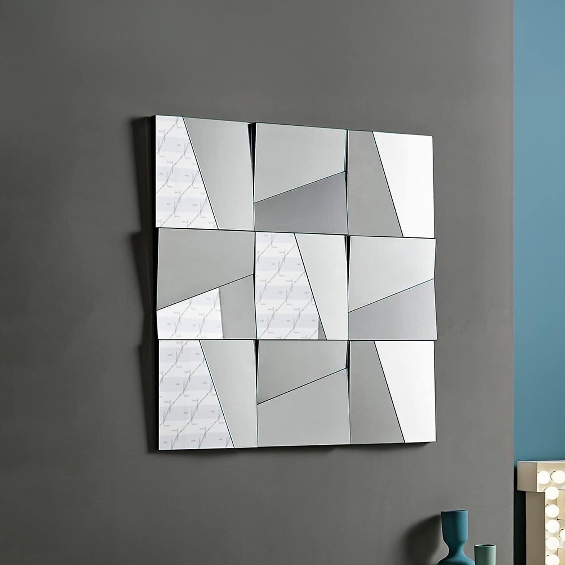 Close-up view of the Stati d’Animo wall mirror emphasizing the play of light and shadow across concave and convex mirror panels.