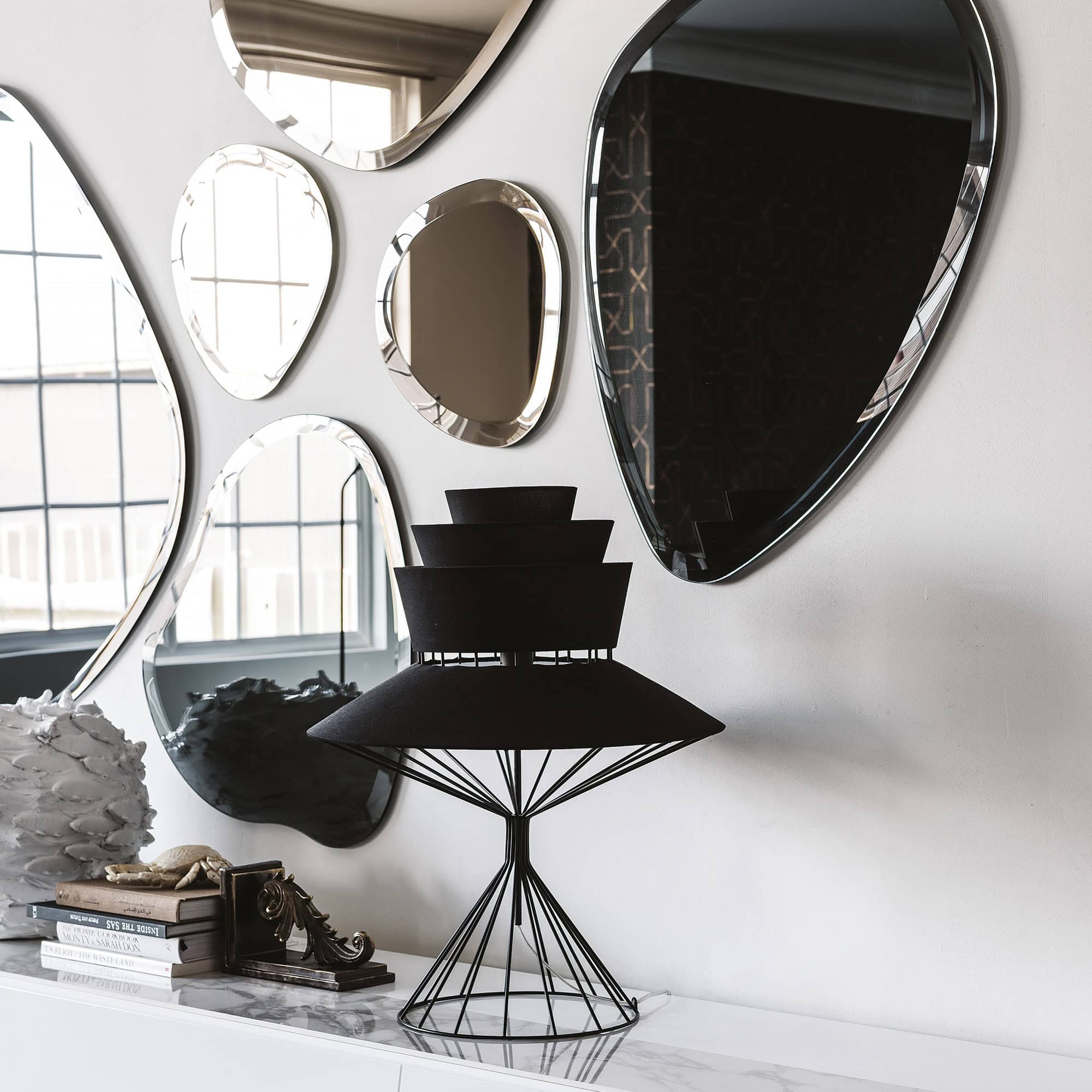 Cluster of Hawaii wall mirrors in organic shapes creating a striking accent above a console table.