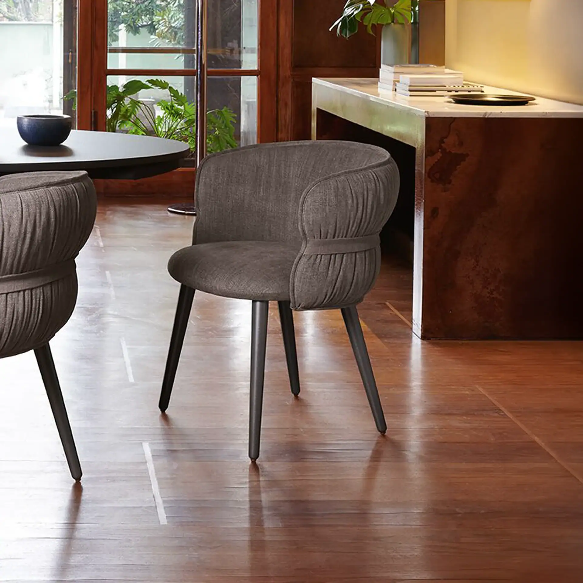 Modern gray dining armchair with wooden legs in stylish interior.