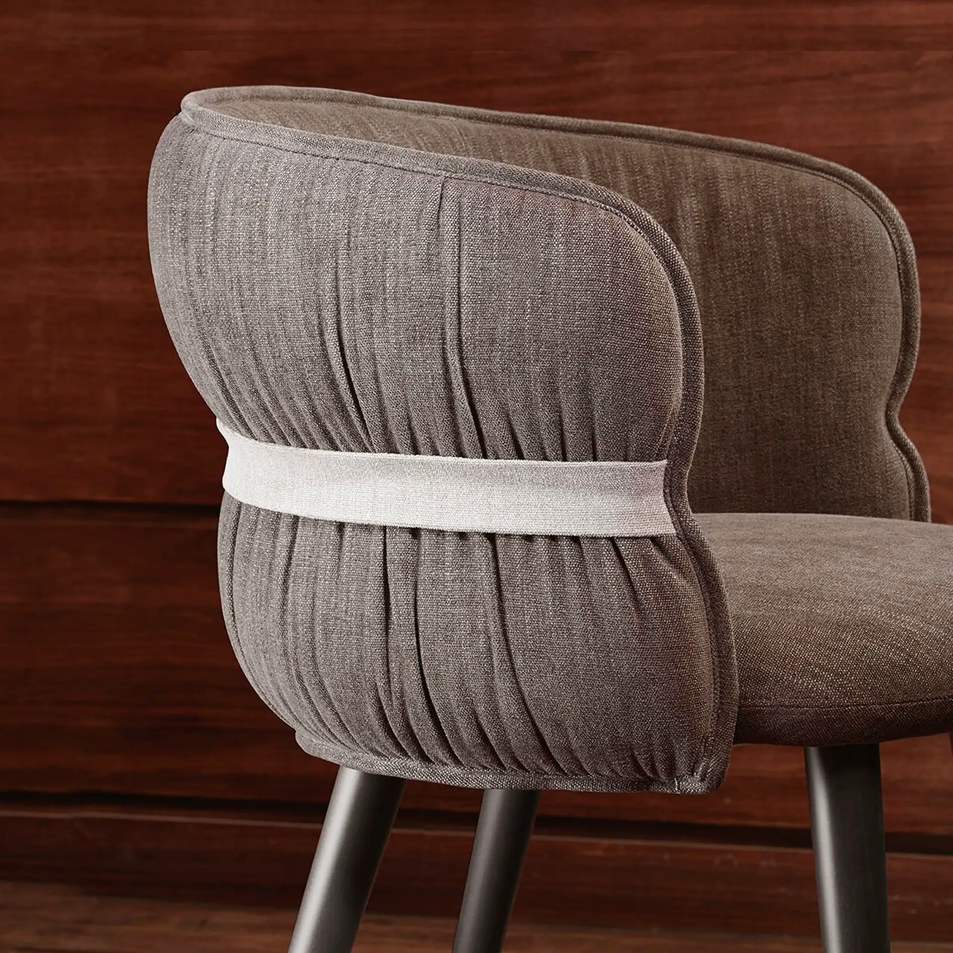Modern grey armchair with curved back and black legs for stylish living rooms.