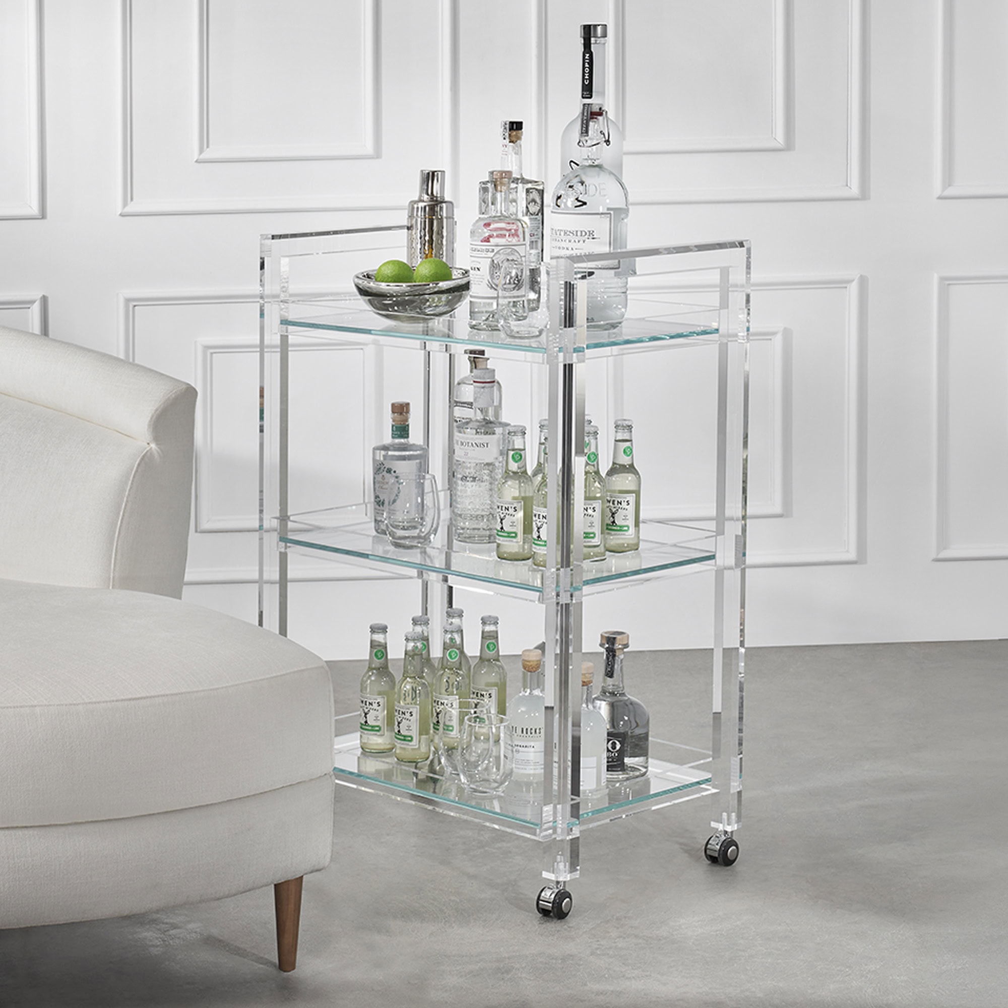 Acrylic bar cart with bottles and glasses, perfect for modern home bar setups.