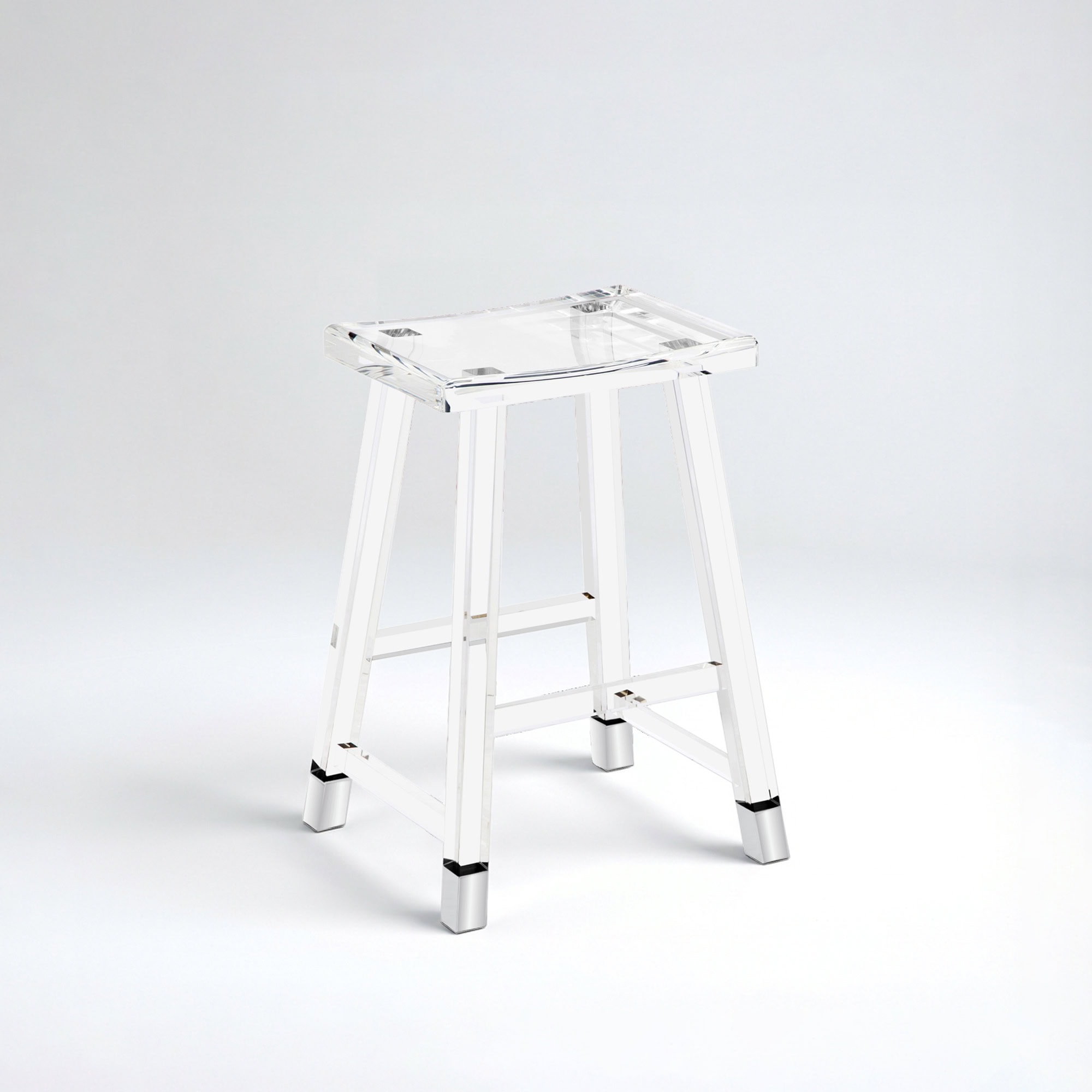 A clear acrylic stool with a saddle-shaped seat and polished silver metal caps on its feet, set against a light grey background.
