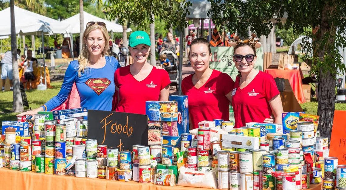Superhero-themed volunteers at food drive supporting local community food bank.