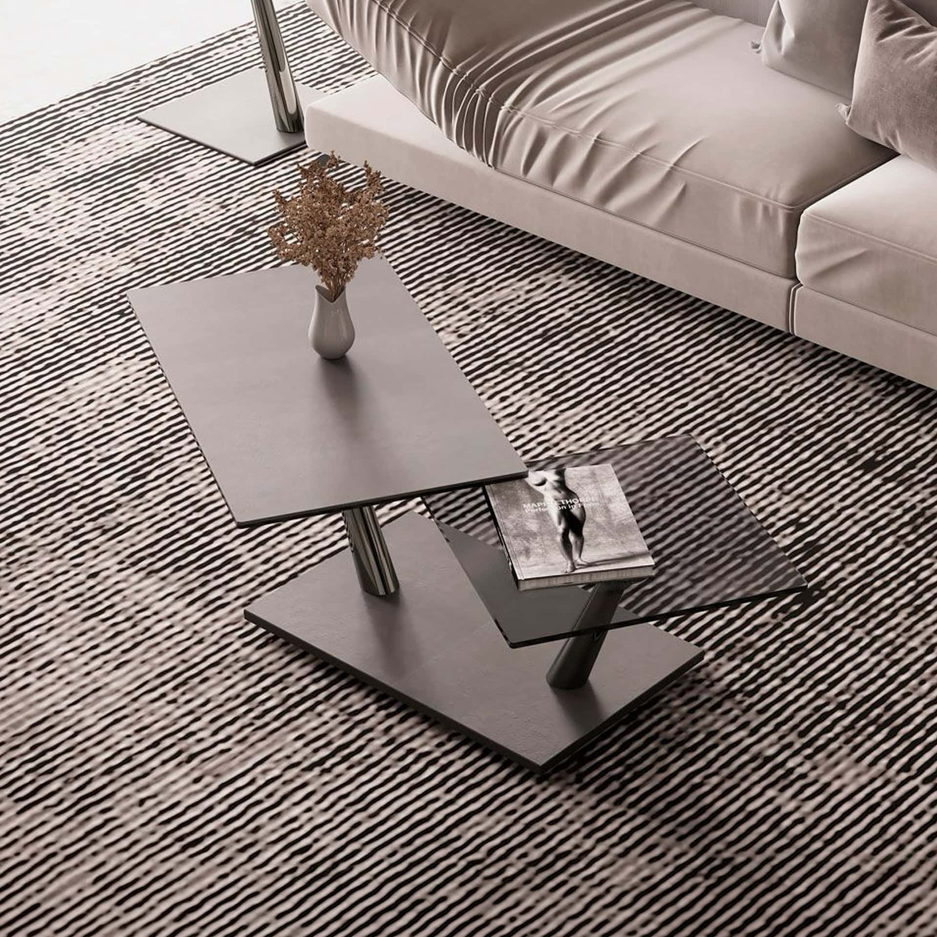 Modern Aqui Motion cocktail table with layered glass and metal design in living room.