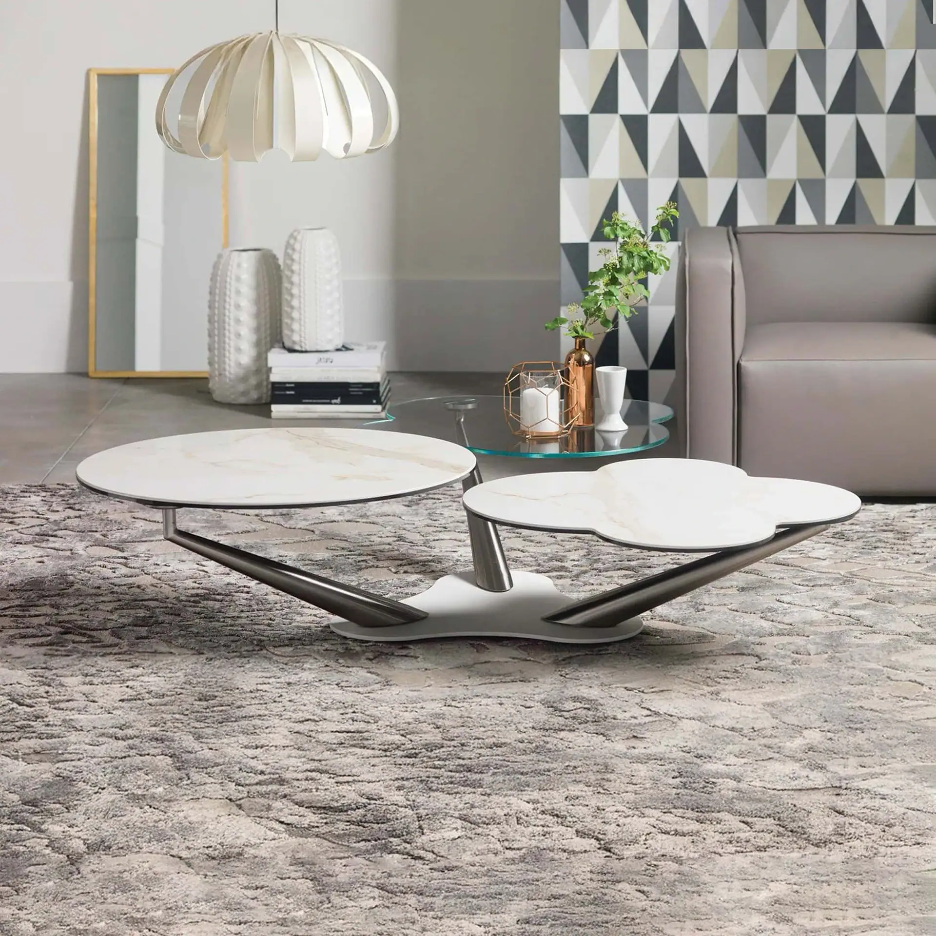 Modern rotating coffee table with white marble top and unique base design.