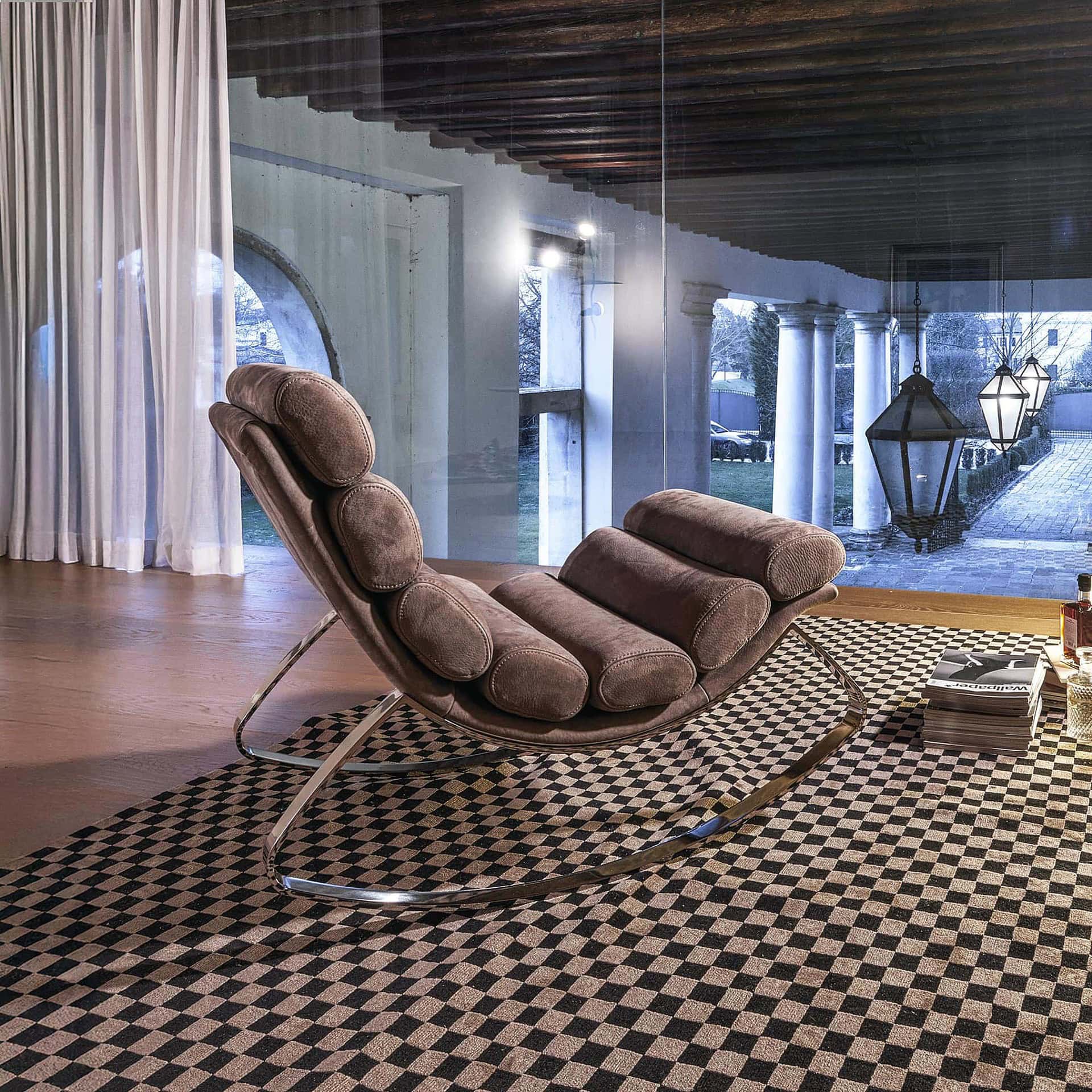 Monet Rocking Chair in taupe leather, placed in a contemporary lounge with patterned rug.
