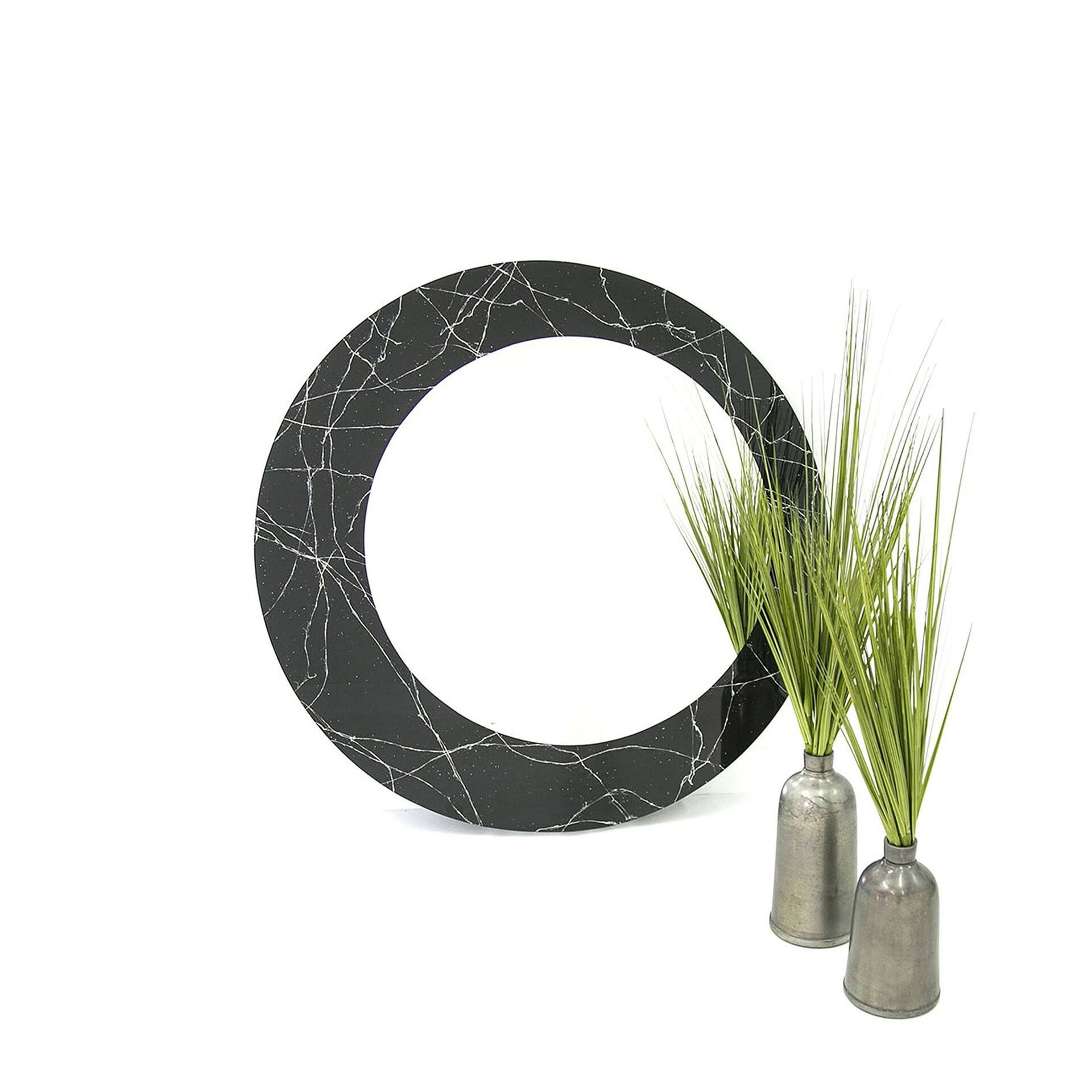 Olio Mirror with dark glass frame shown in a clean cutout with decorative plant.