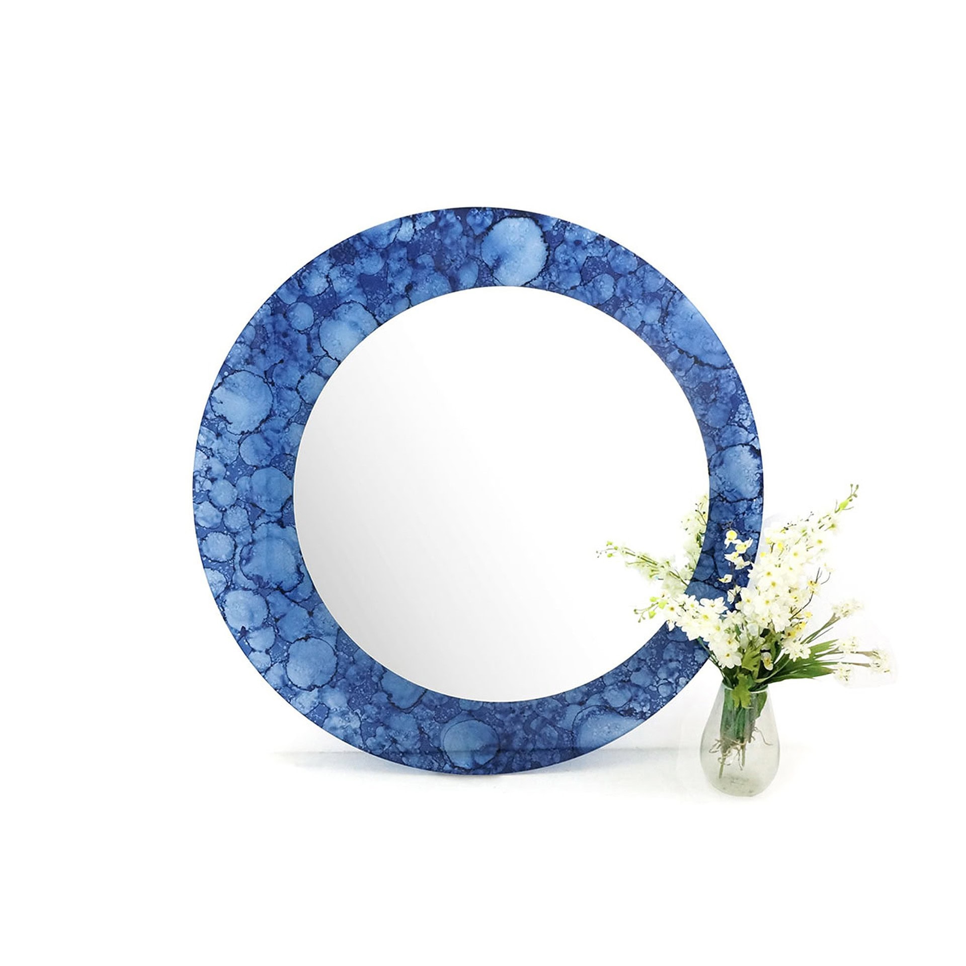 Olio Mirror with blue glass frame displayed with small decorative plant.