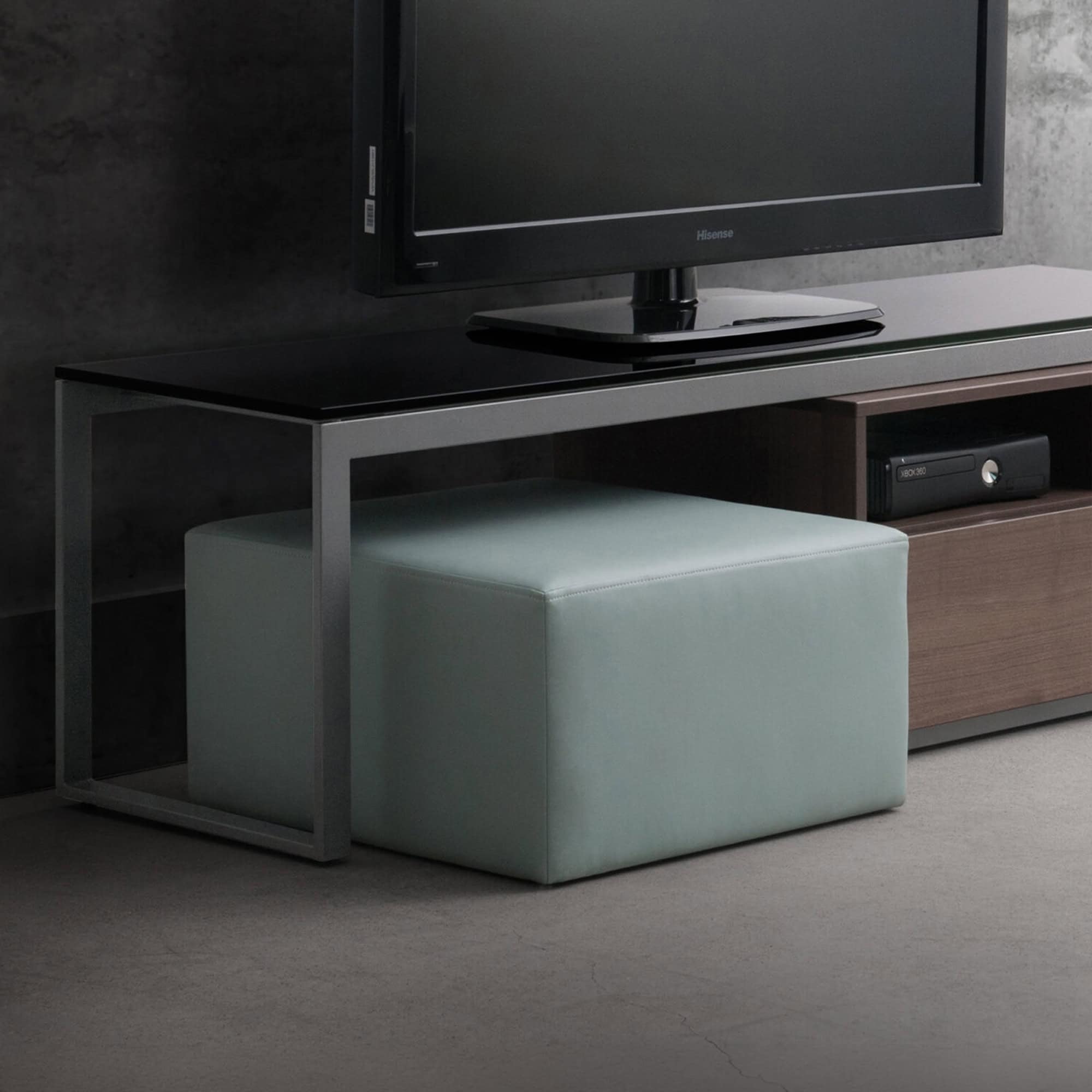 Contemporary upholstered ottoman in a sleek living room setting, perfect for extra seating or footre.