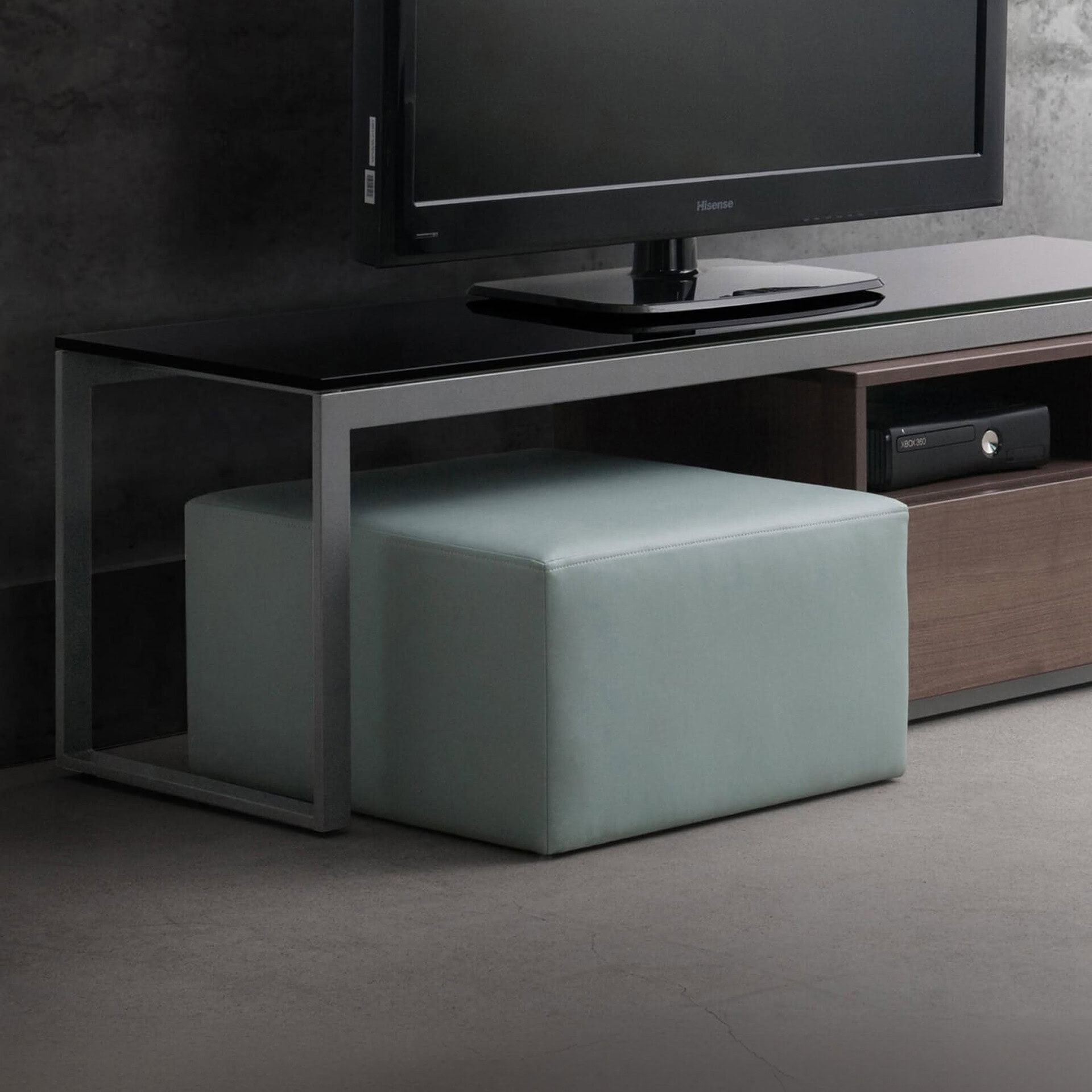 Contemporary upholstered ottoman in a sleek living room setting, perfect for extra seating or footre.