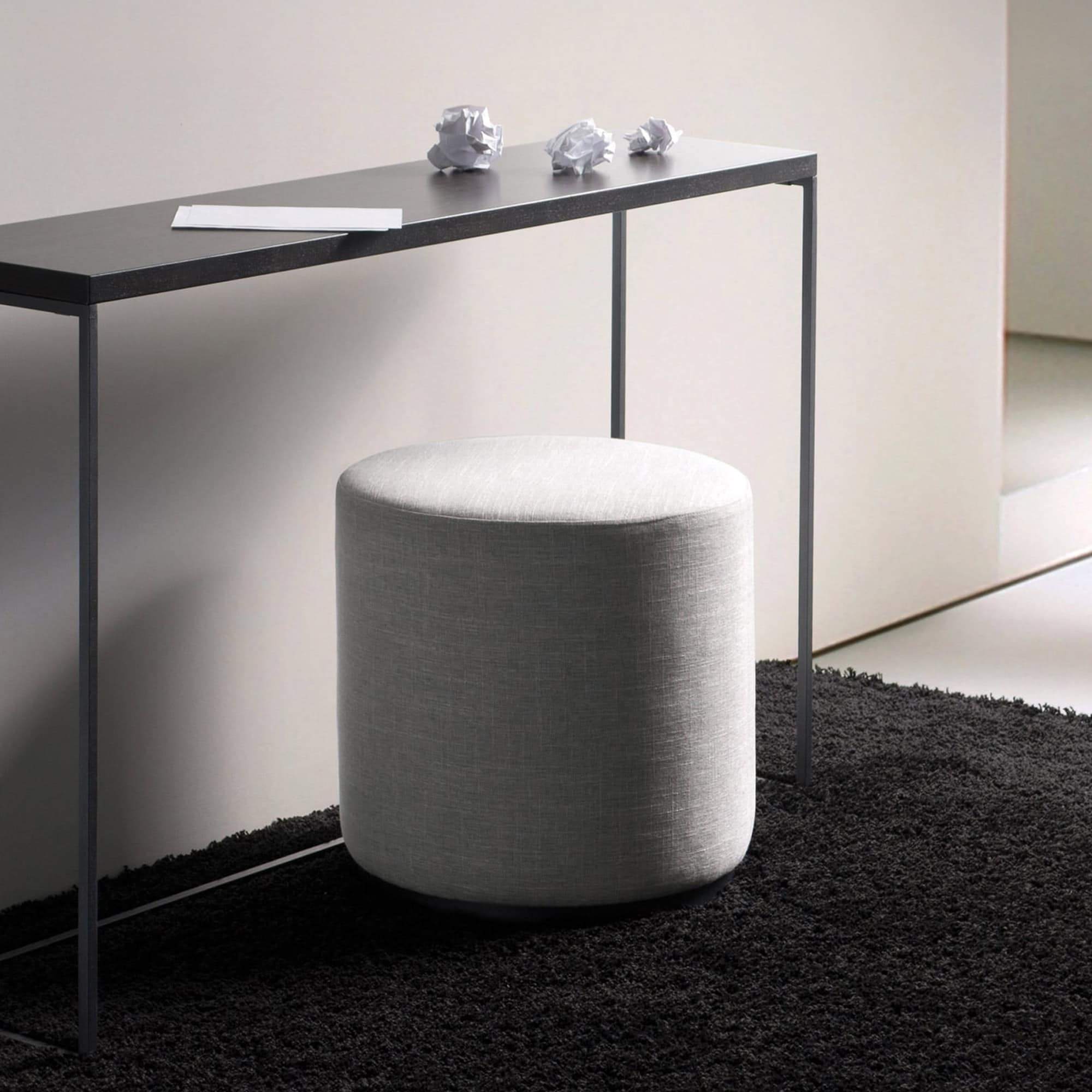 Ottoman with grey fabric upholstery in a contemporary living space.