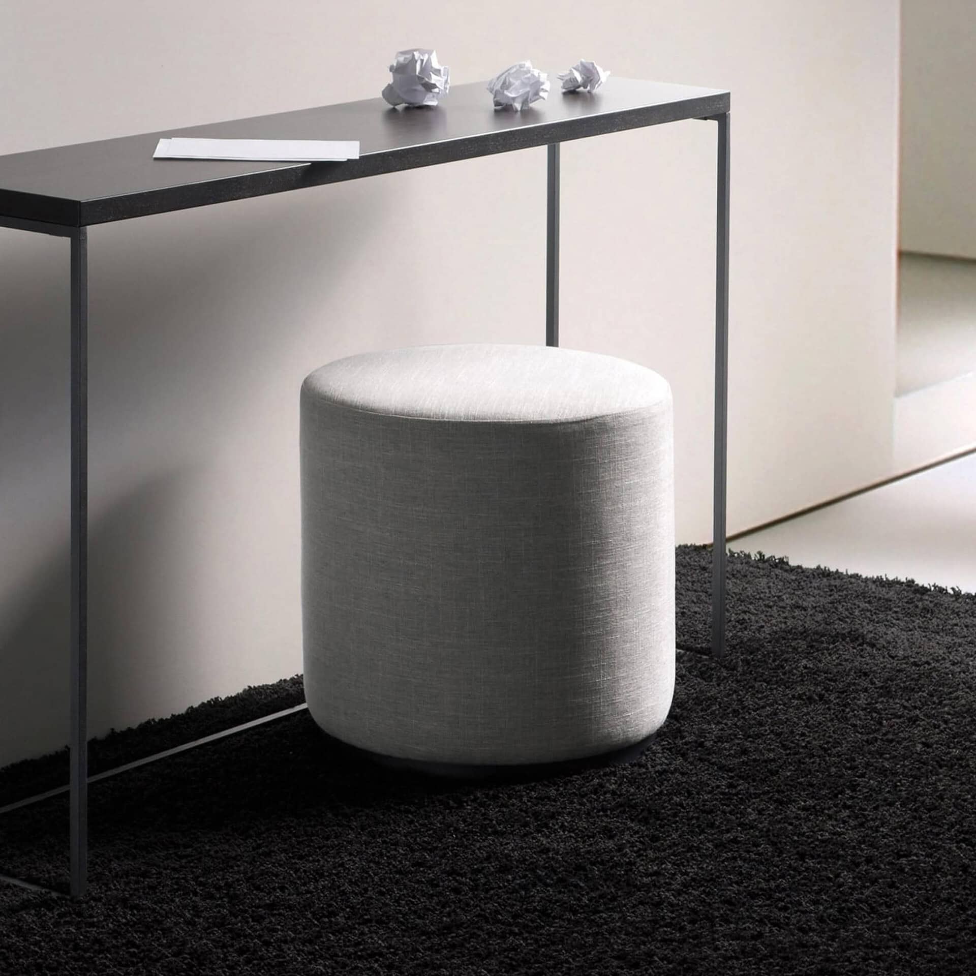 Ottoman with grey fabric upholstery in a contemporary living space.