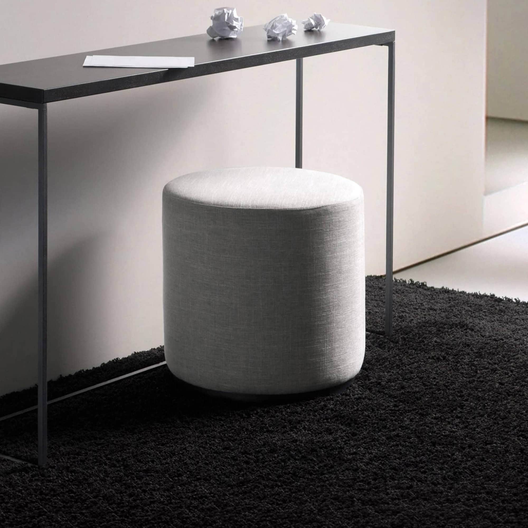 Ottoman with grey fabric upholstery in a contemporary living space.