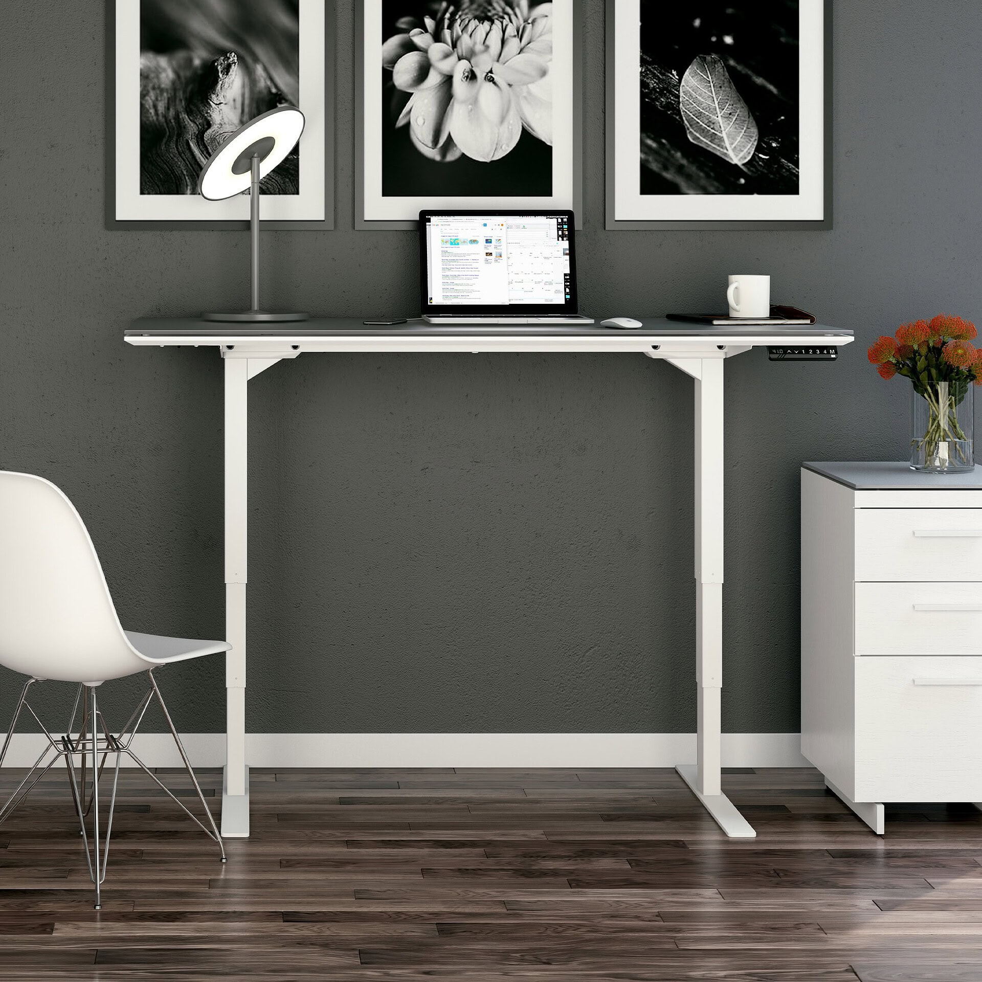 Modern adjustable height white desk with laptop and office accessories, sleek home workspace.
