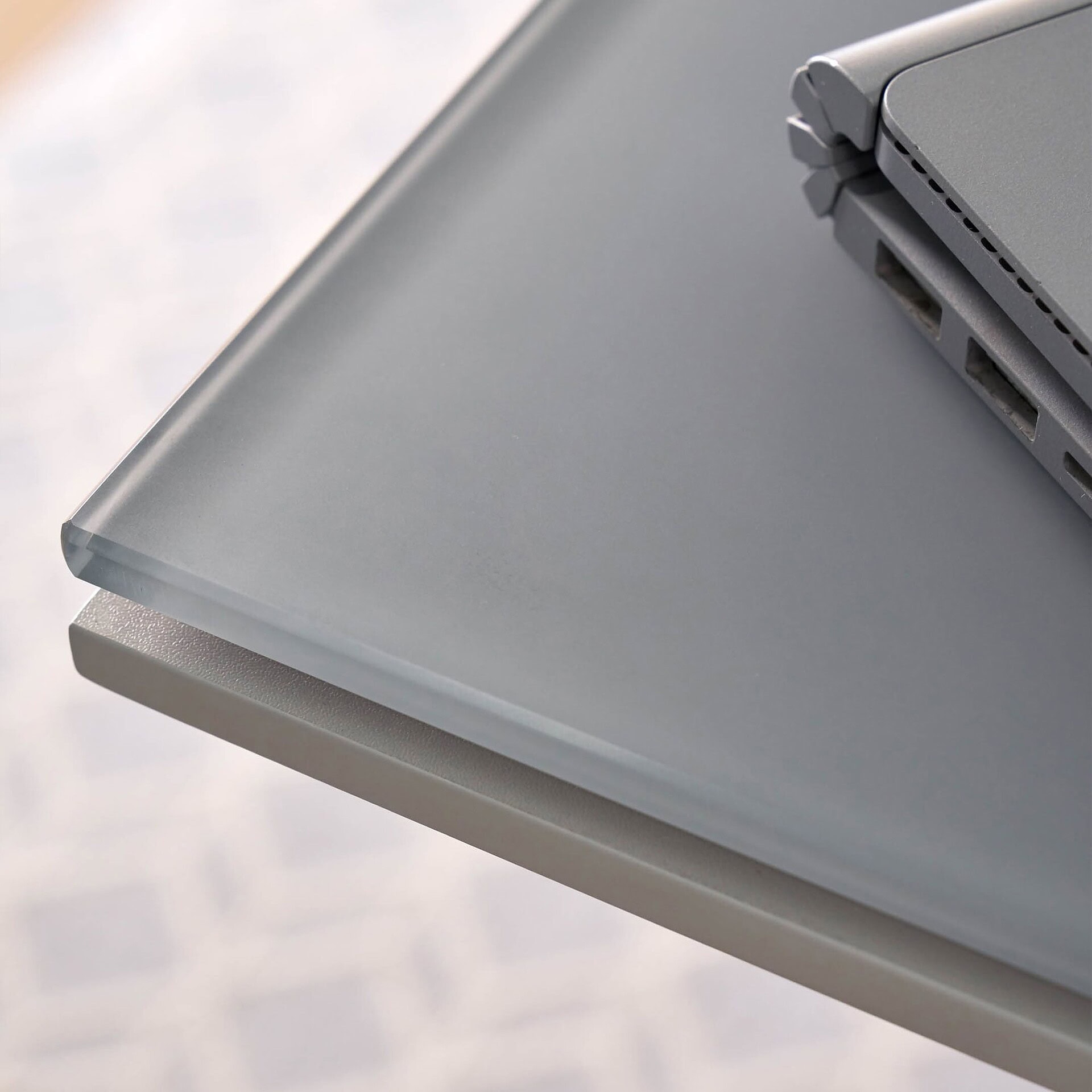 Sleek modern gray desk with built-in USB ports and power outlets for ergonomic workspace solutions.