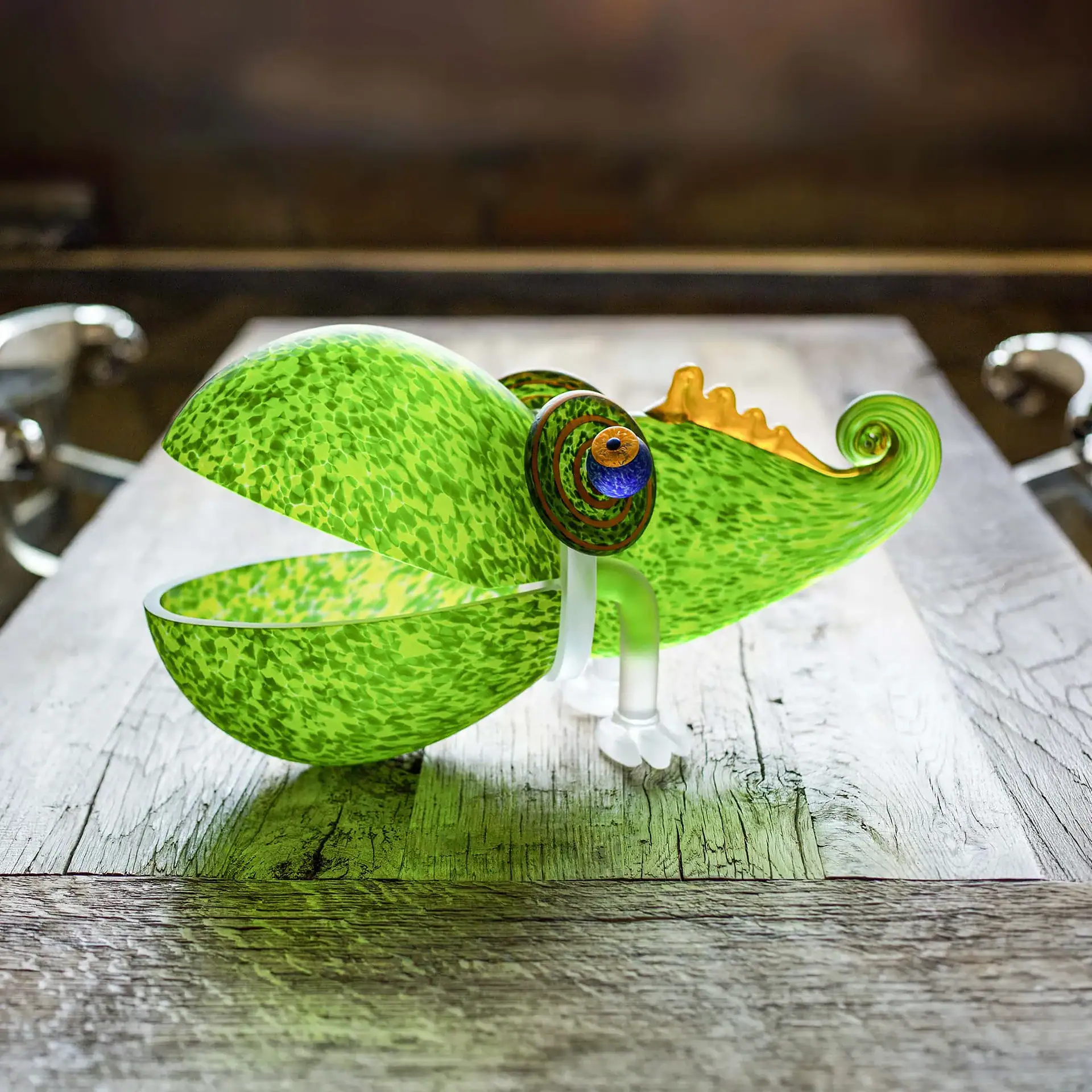 Chameleon Big Glass Bowl with an open mouth, colorful eye, and curled tail, sitting on a rustic wooden table.