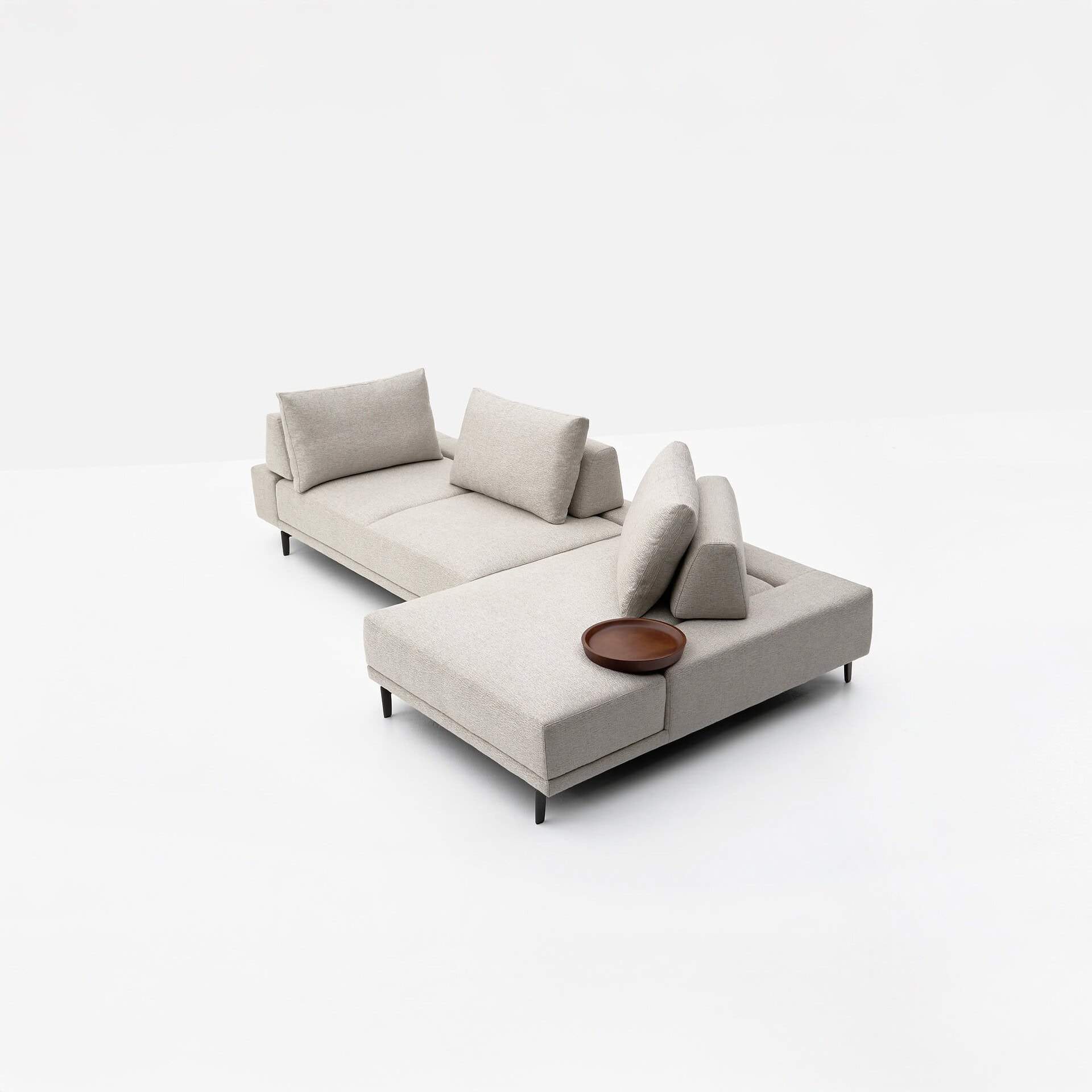 Sofa with beige upholstery and black legs in modern minimalist living room decor.