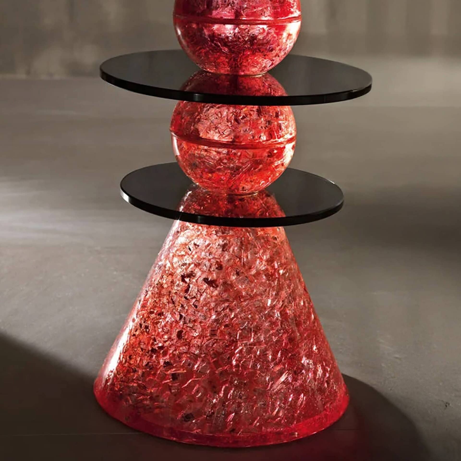 Close-up of Il Paese delle Meraviglie Side Table with red glass base and smoked round glass top