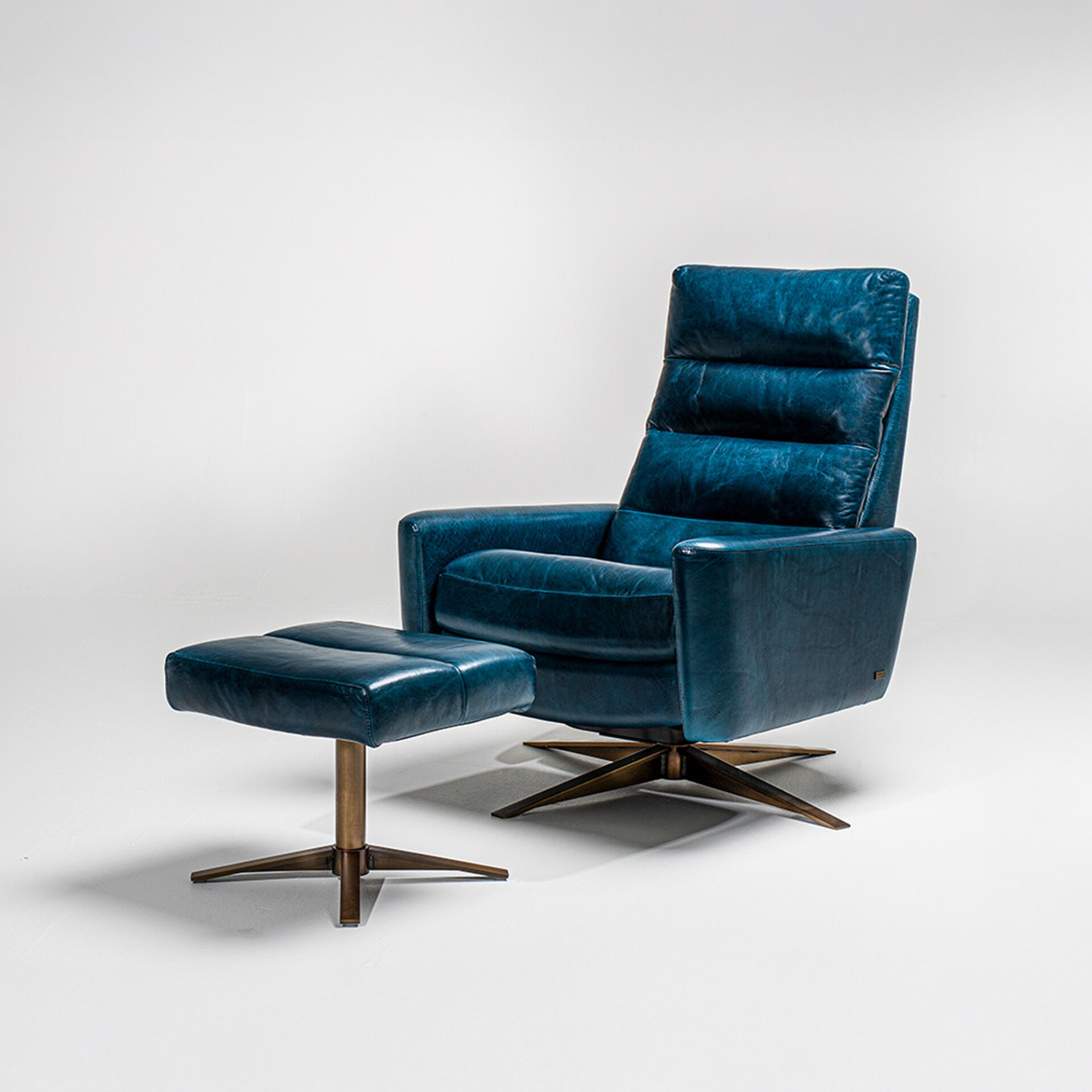 A distressed teal blue leather armchair and matching ottoman with dark bronze four-star bases, set against a white background.