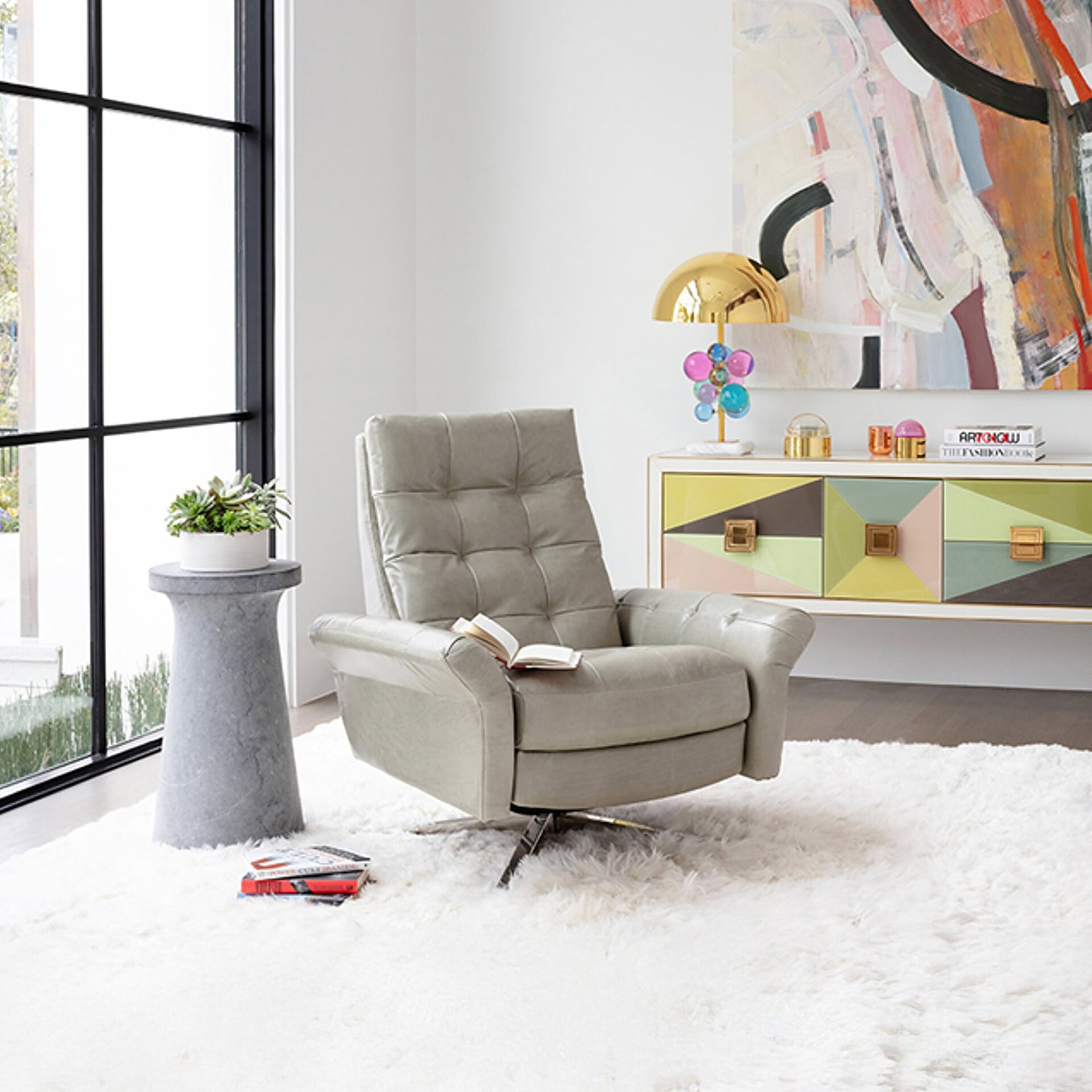 Lifestyle view of Pileus Comfort Air Chair in grey fabric, placed near a window in a bright living room.